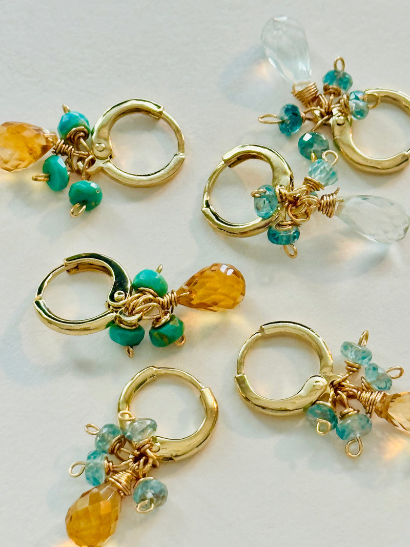 Huggie earrings featuring turquoise on a light background