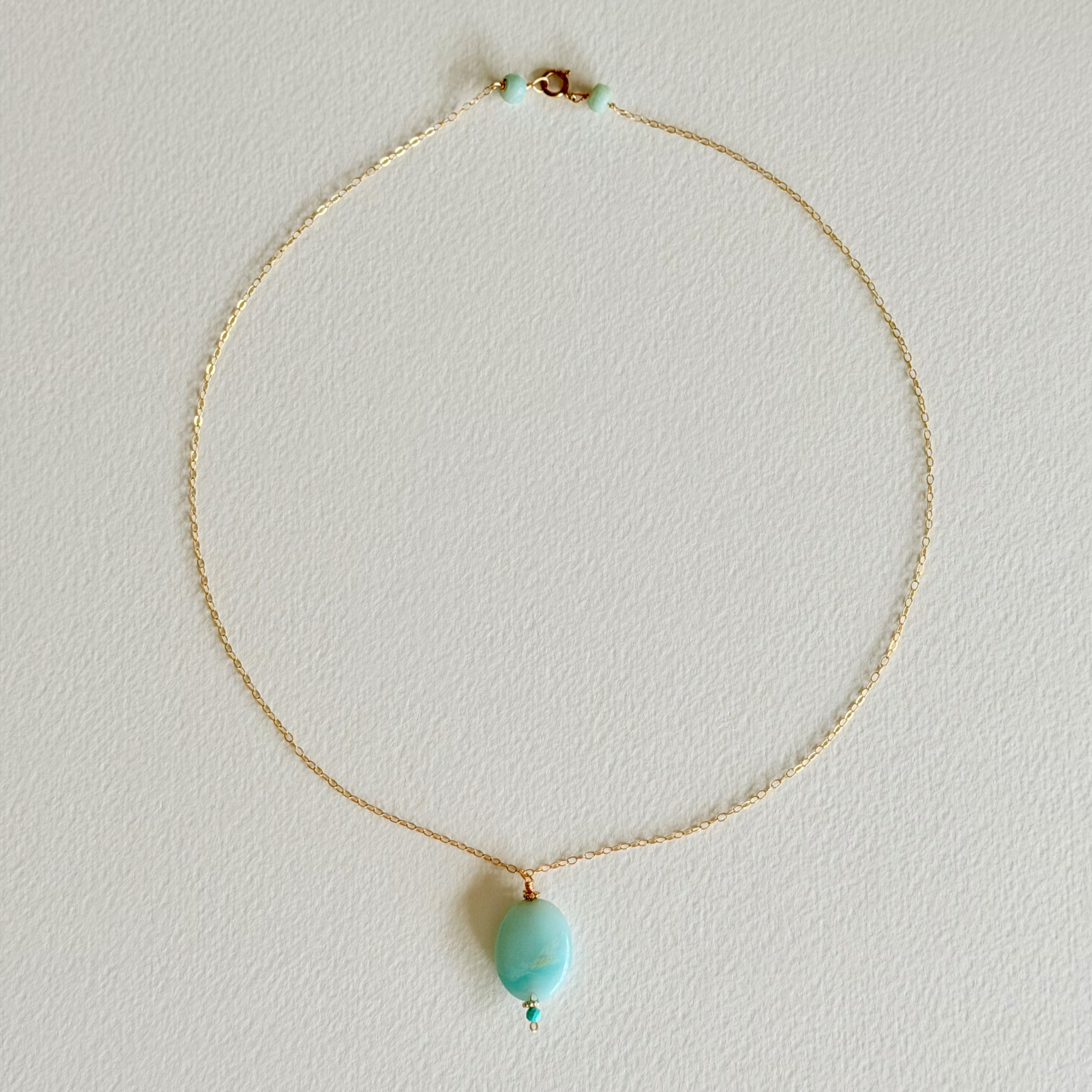 Necklace with a turquoise pendant on a light gray background