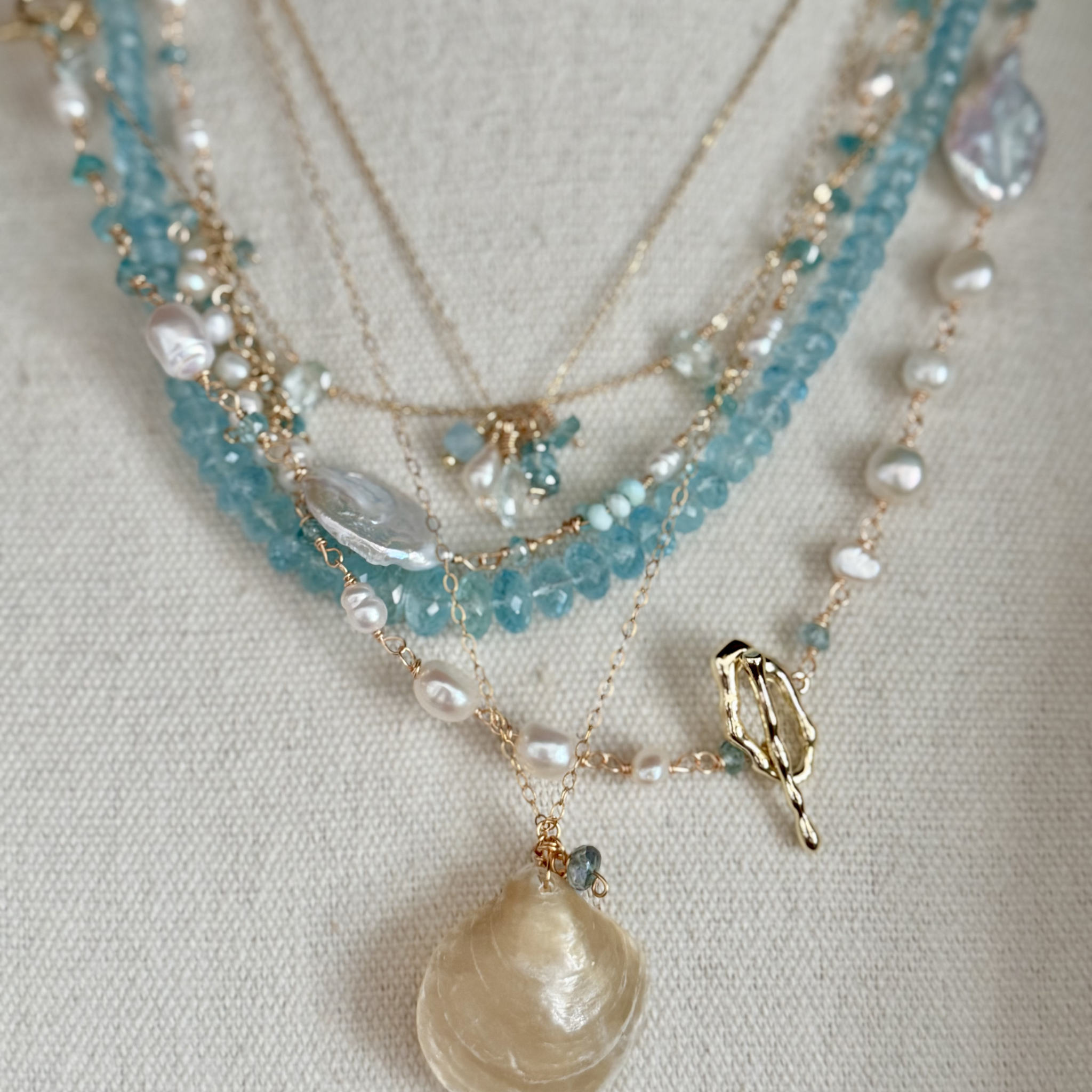 Necklace with pearls and blue beads on a light background