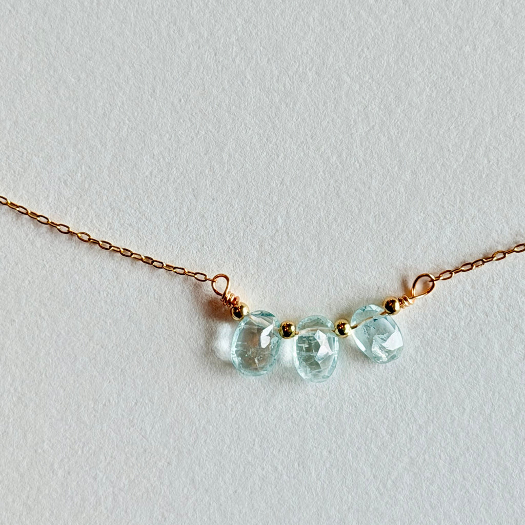 Delicate necklace with light blue beads on a white background