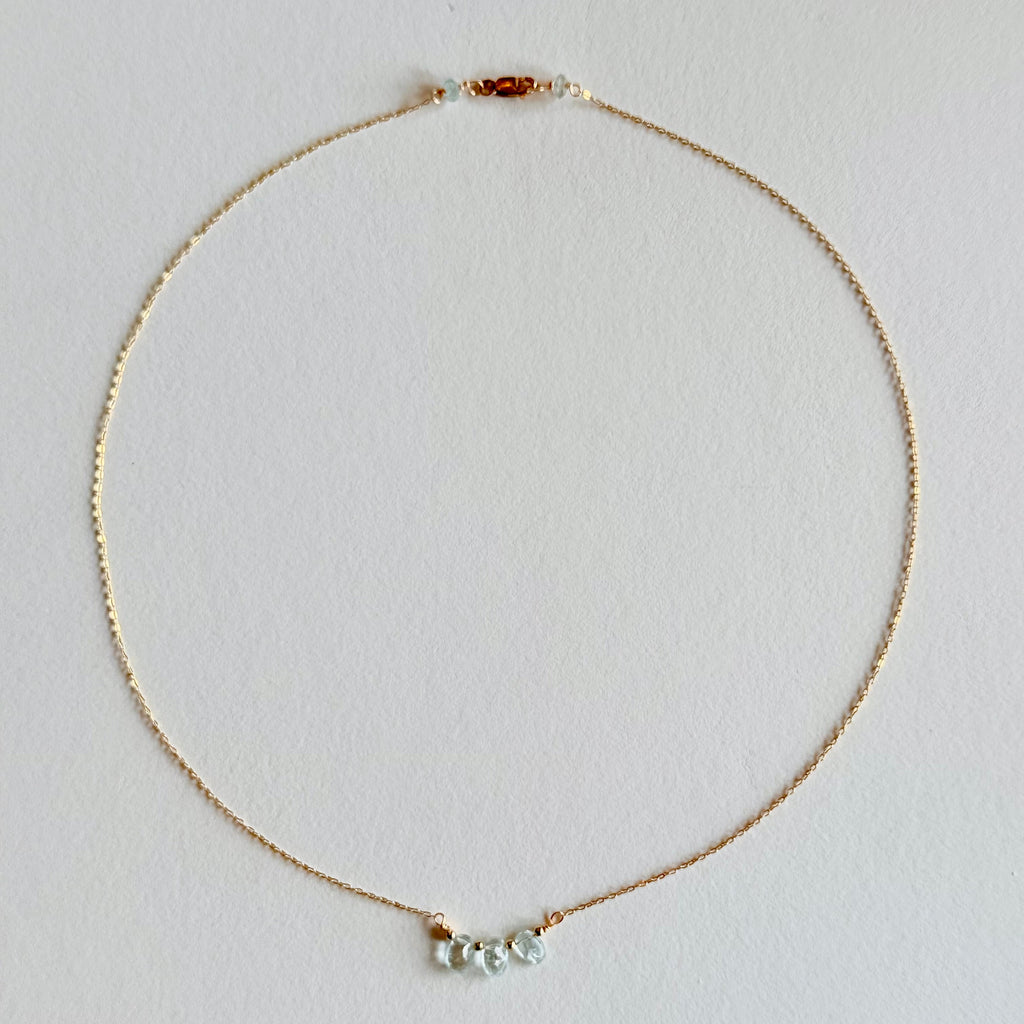 Delicate necklace with small beads on a light gray background