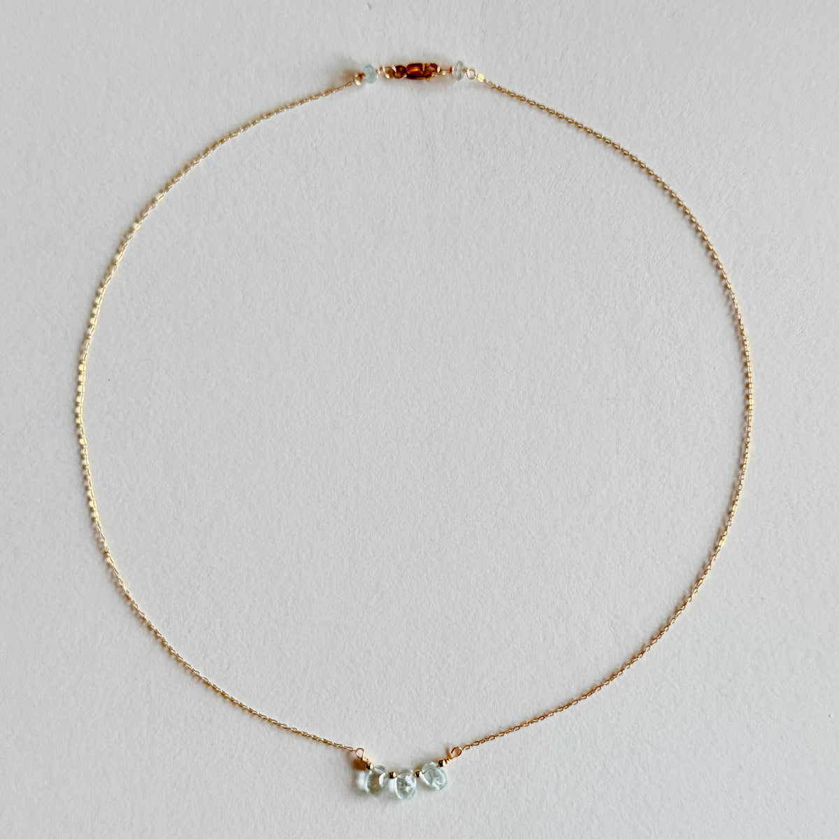 Delicate necklace with small beads on a light gray background