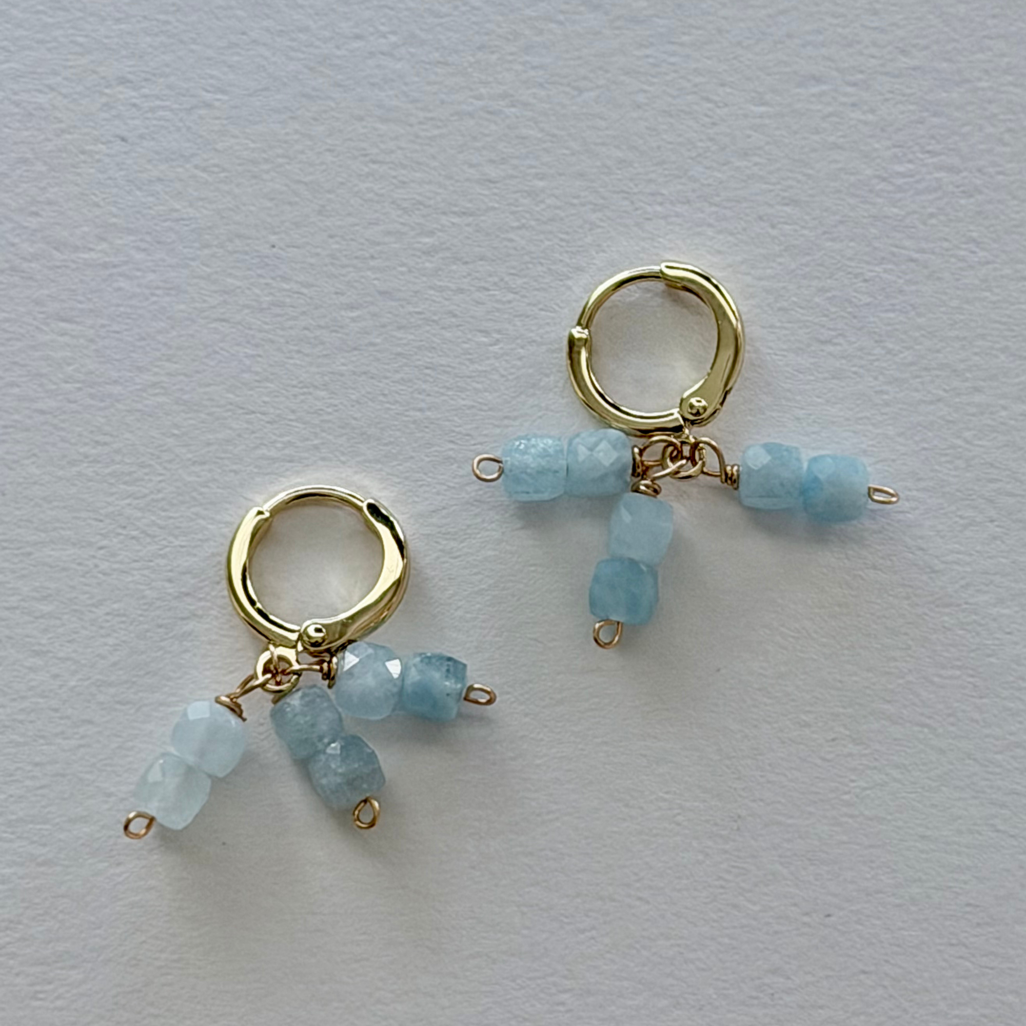 14k Gold filled huggie earrings with blue amethyst beads on a light gray background