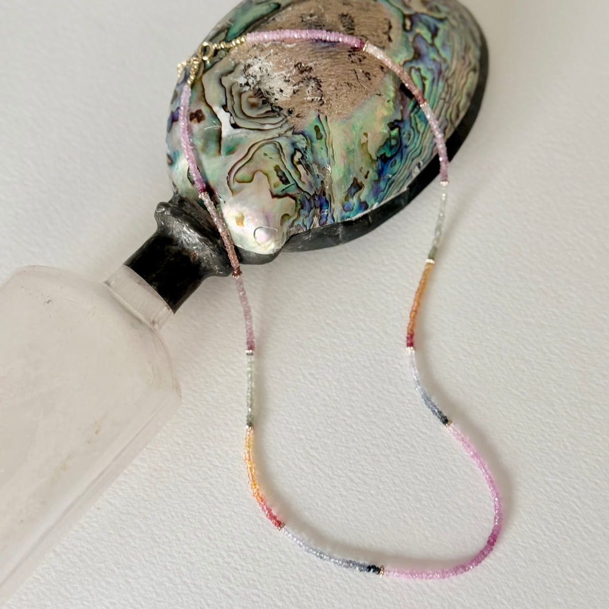 sapphire beaded necklace on a seashell bottle