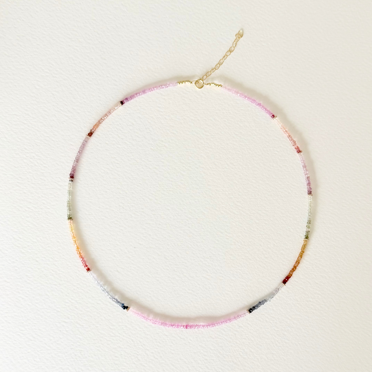multi colored sapphire beaded necklace on light background