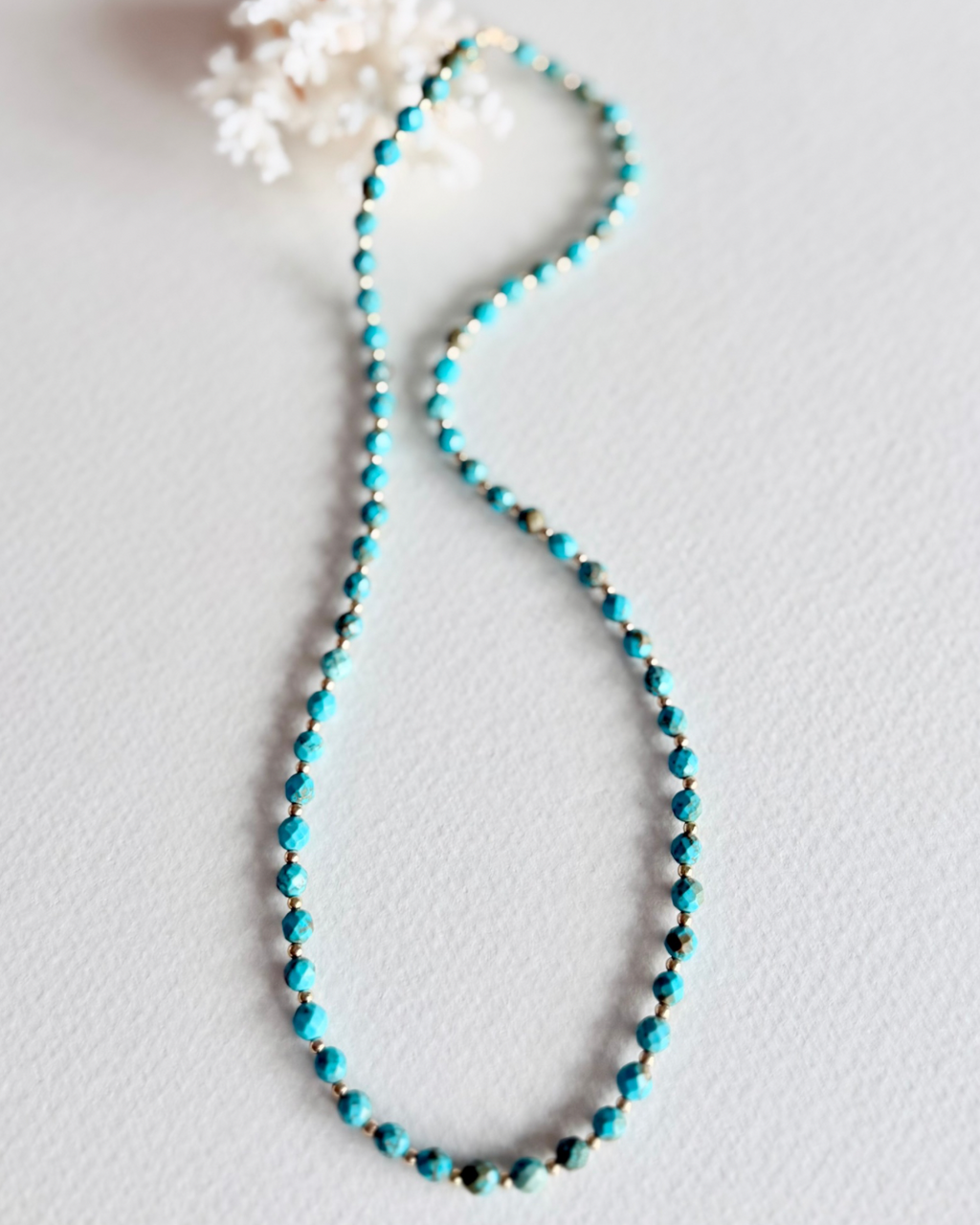 Close-up of Blue Current turquoise necklace beads and gold filled details