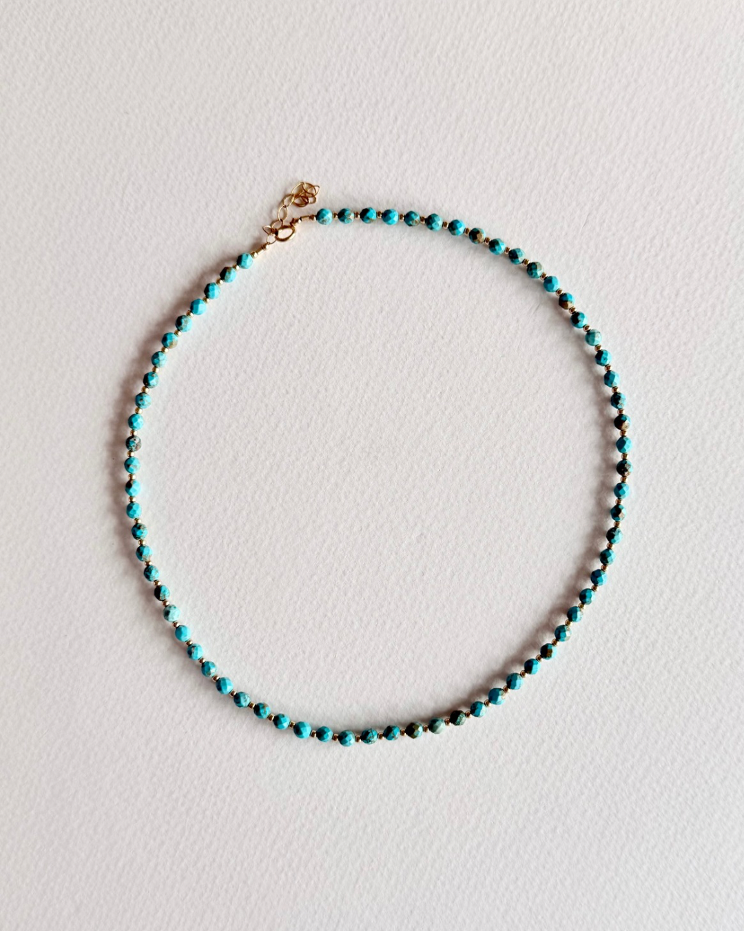 Blue Current turquoise beaded necklace on light background