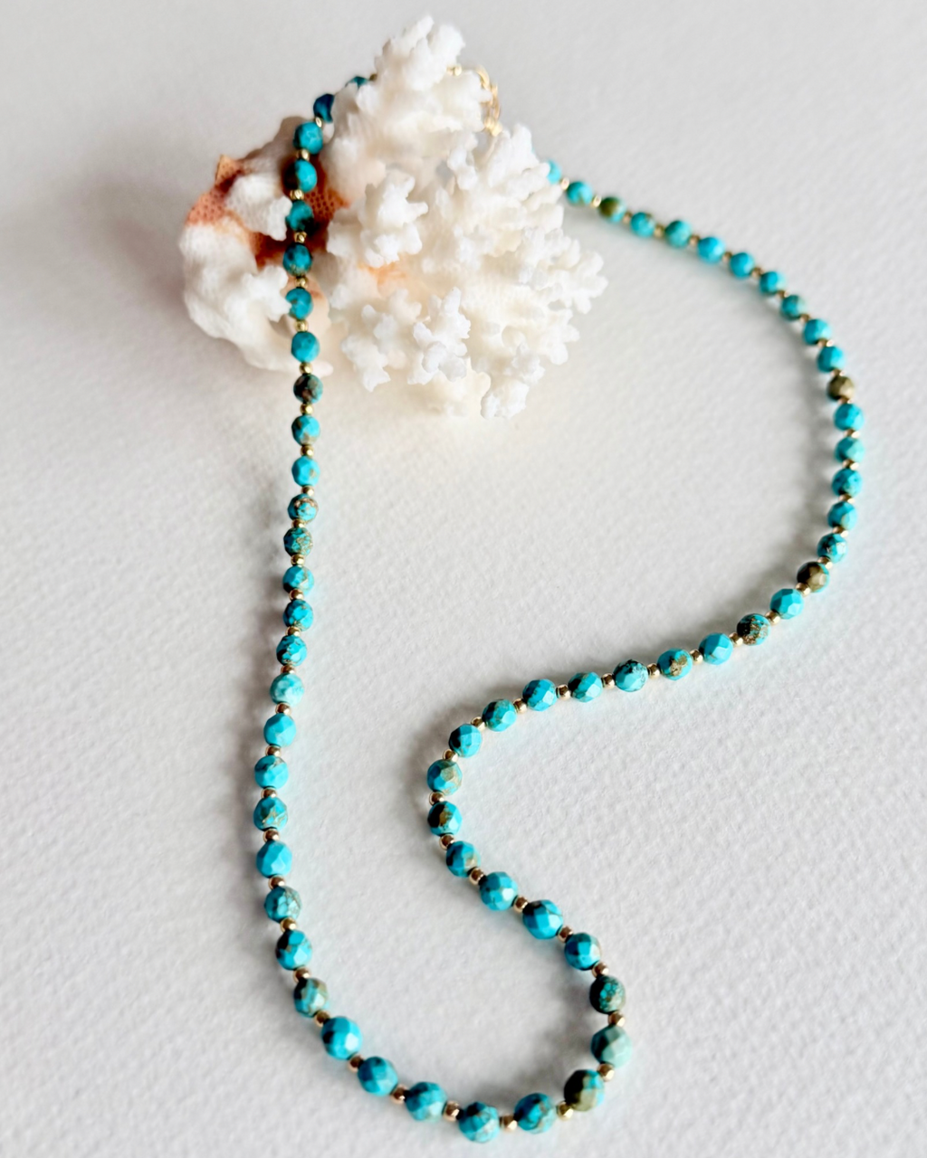 Blue Current turquoise necklace styled on coral