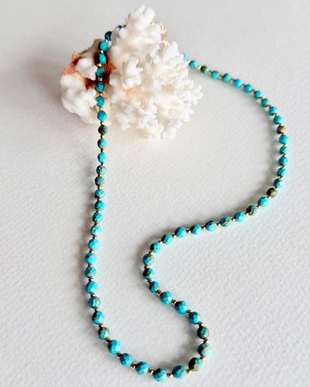 Blue Current turquoise necklace styled on coral