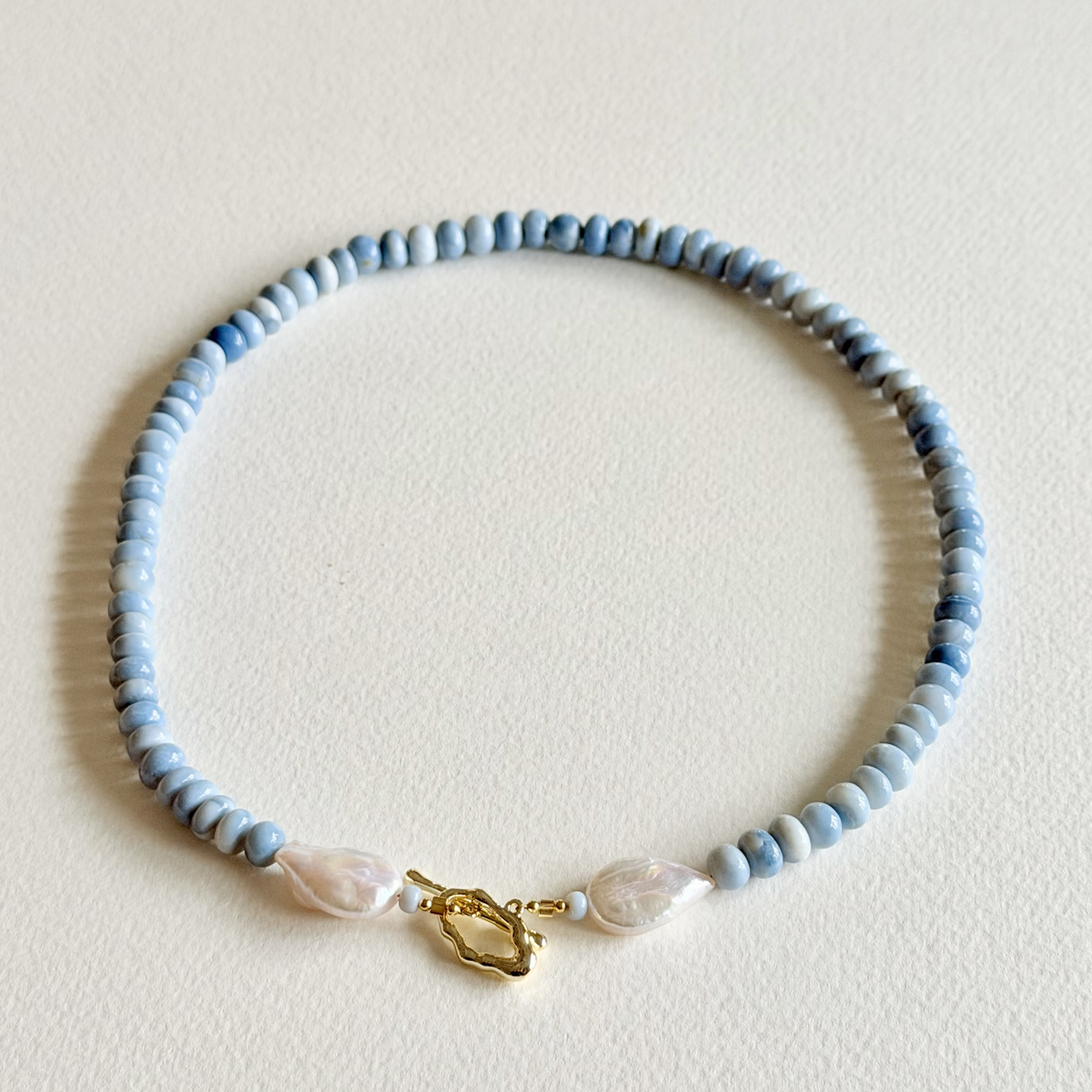 Beaded necklace with a gold clasp on a light background