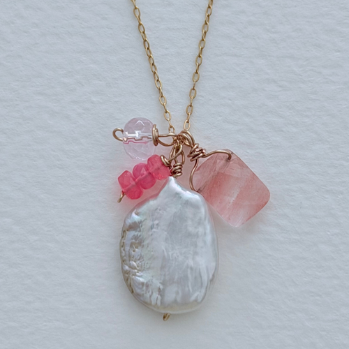 Necklace with pink and opal pendant on a light gray background