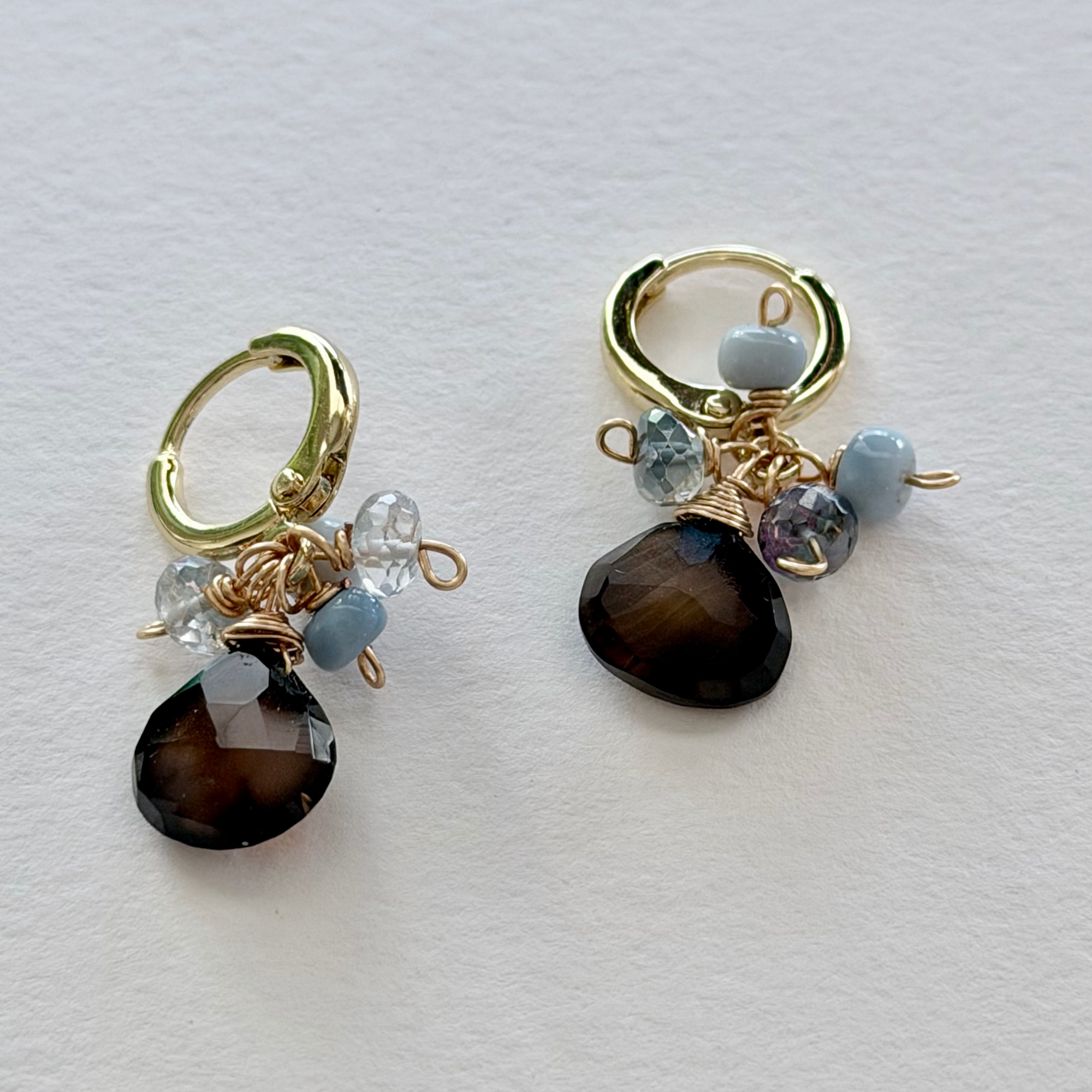 Pair of 14k gold filled huggie earrings with chocolate chalcedonty and nystic topaz and denim opal gemstones on a white background