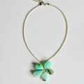 Necklace with a green pendant on a light gray background