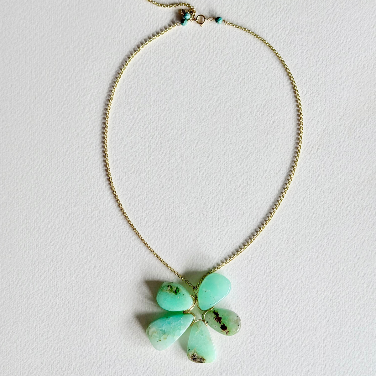 Necklace with a green pendant on a light gray background