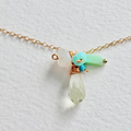 Necklace with teardrop-shaped pendant and colorful beads on a light background