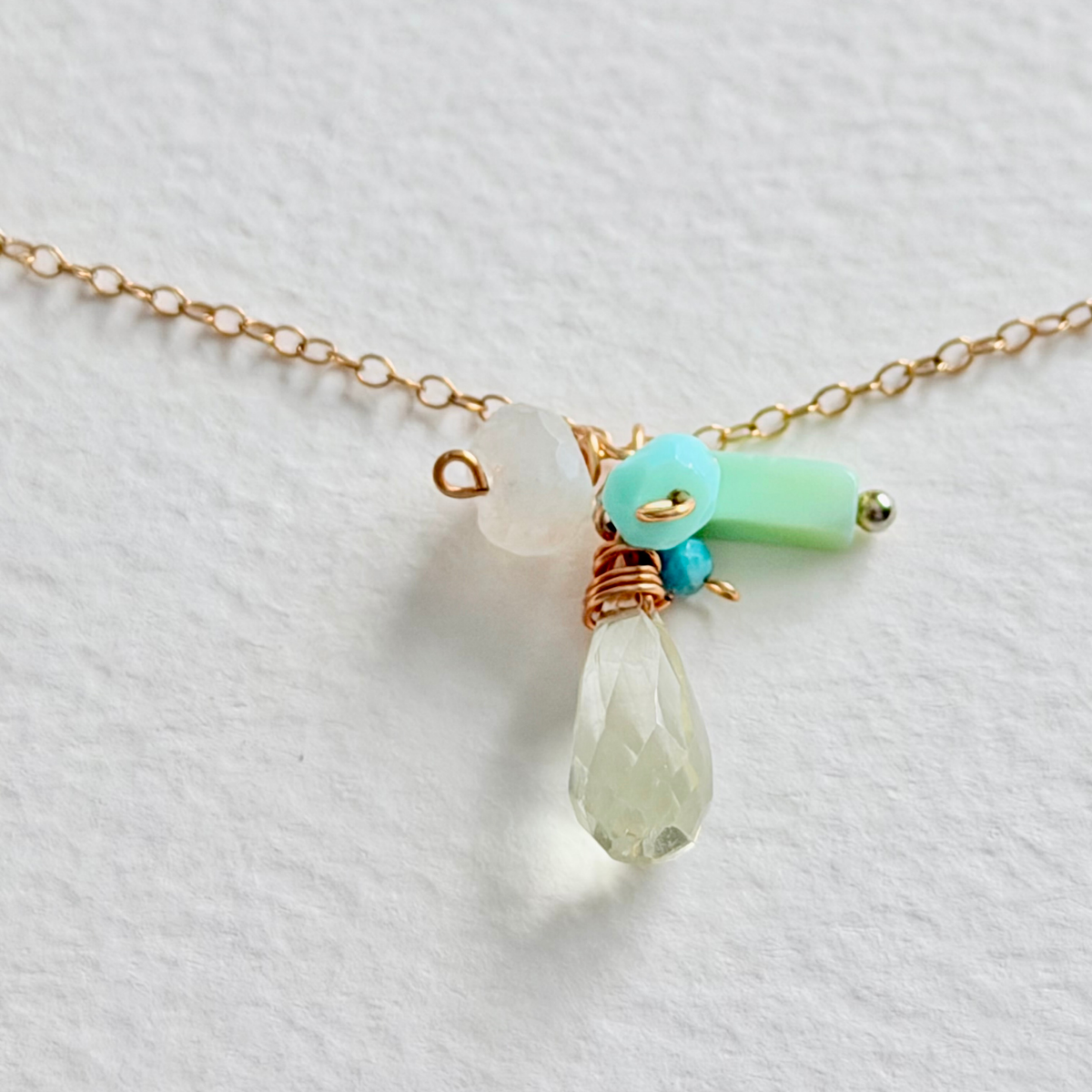 Necklace with teardrop-shaped pendant and colorful beads on a light background