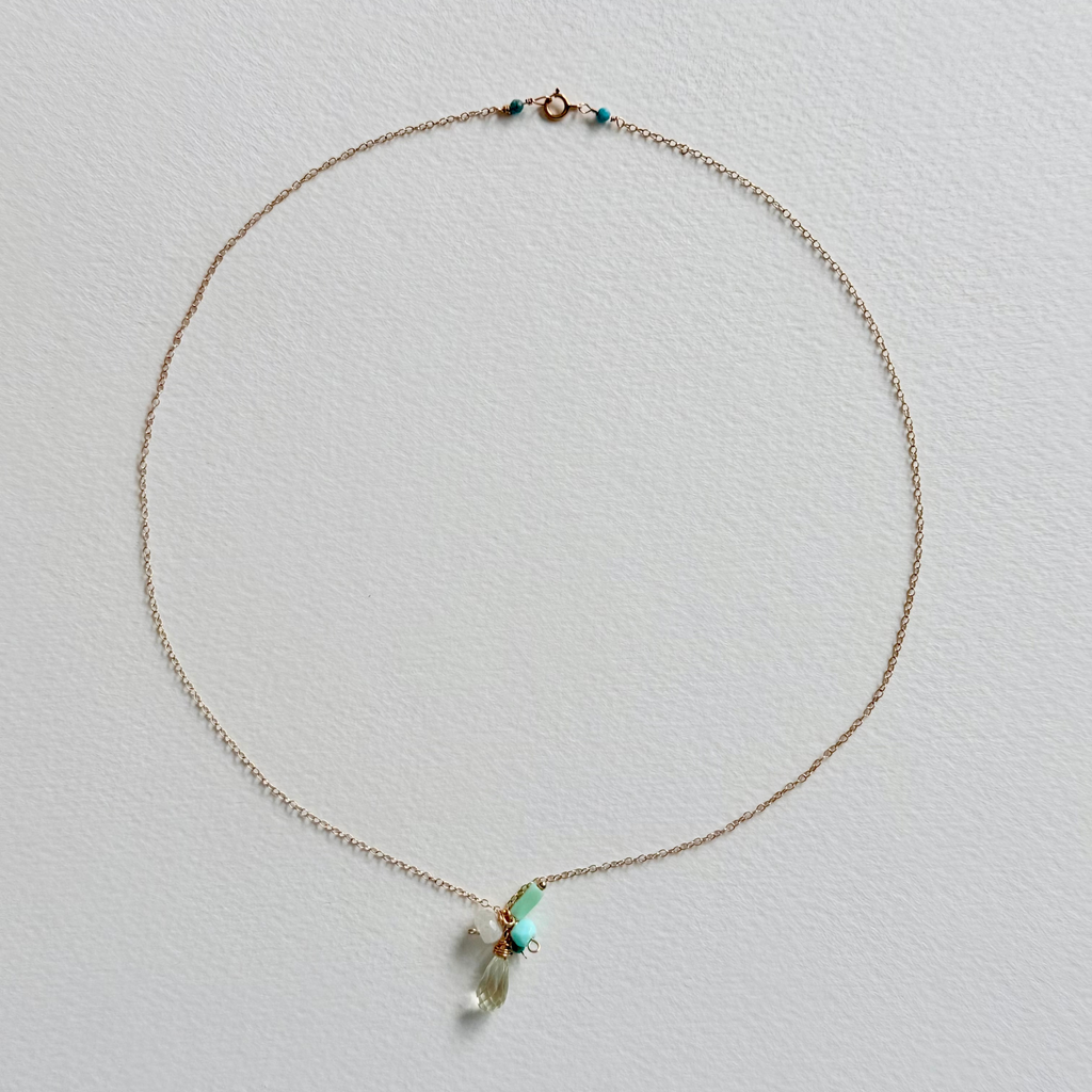 Delicate necklace with a small pendant on a light gray background