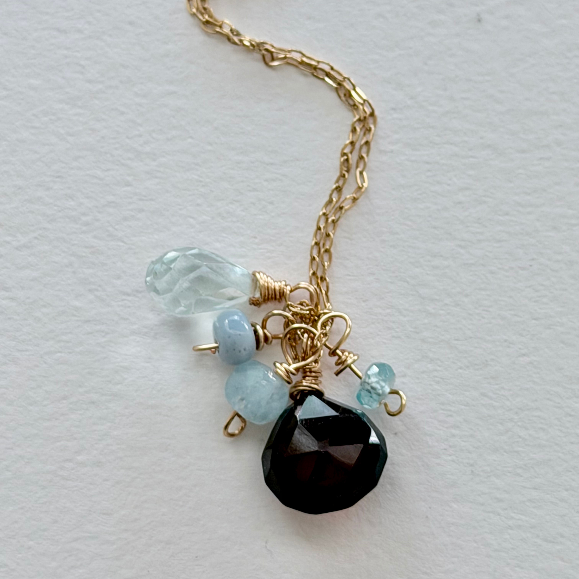 Necklace with 14k gold filled chain, blue beads, and a chocolate chalcedony pendant on a light gray background