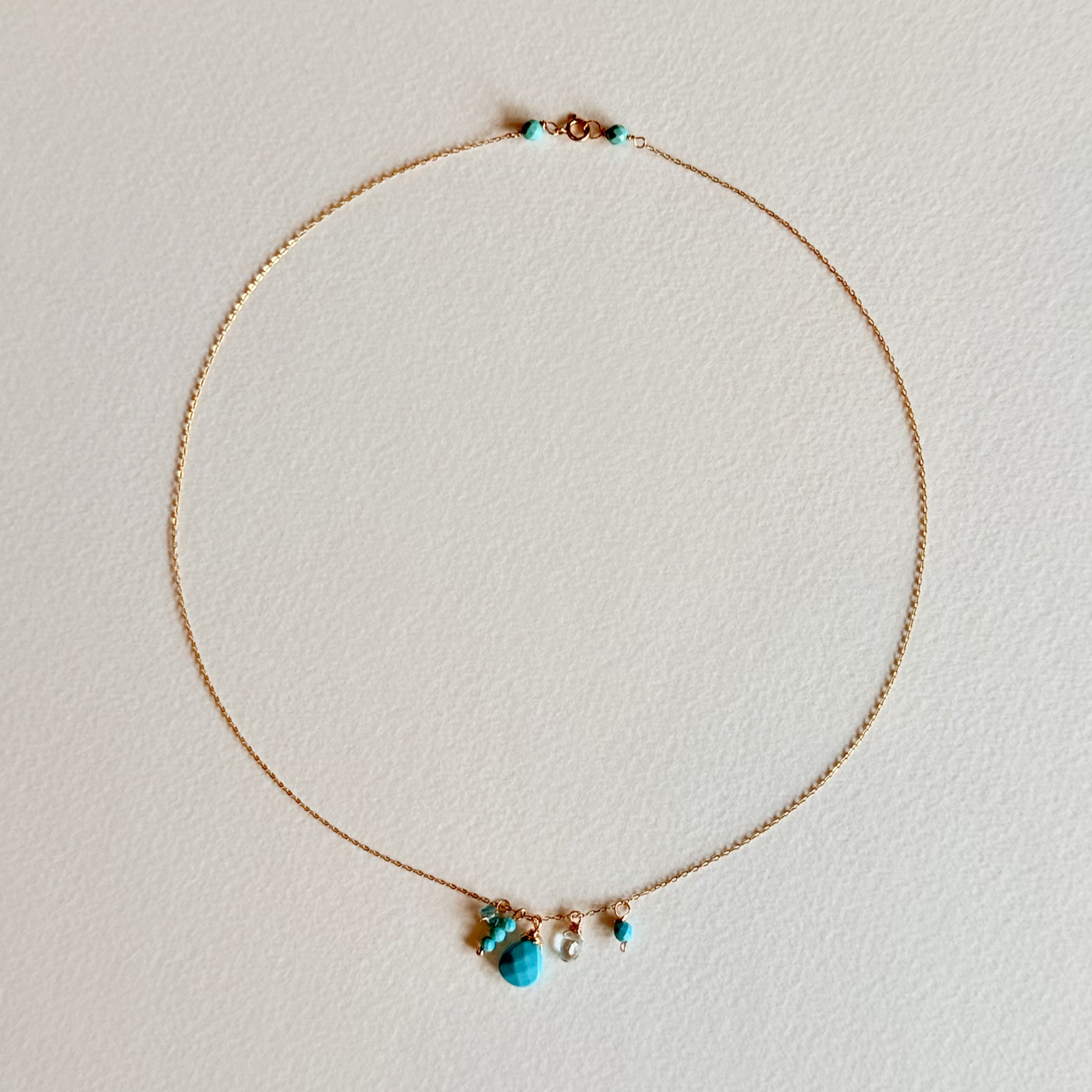 Delicate necklace with turquoise beads on a light background