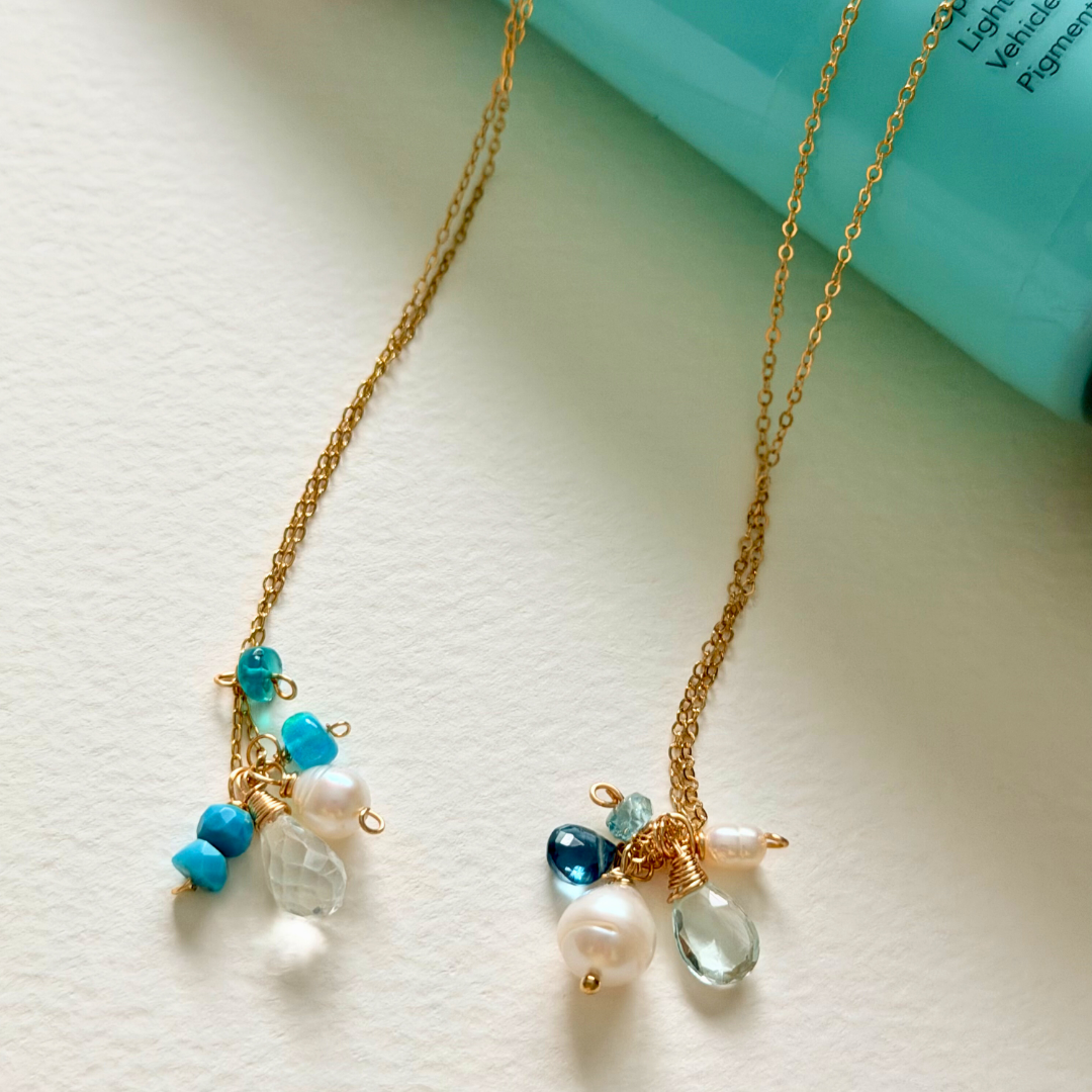 Necklace with blue and clear bead charms on a light background