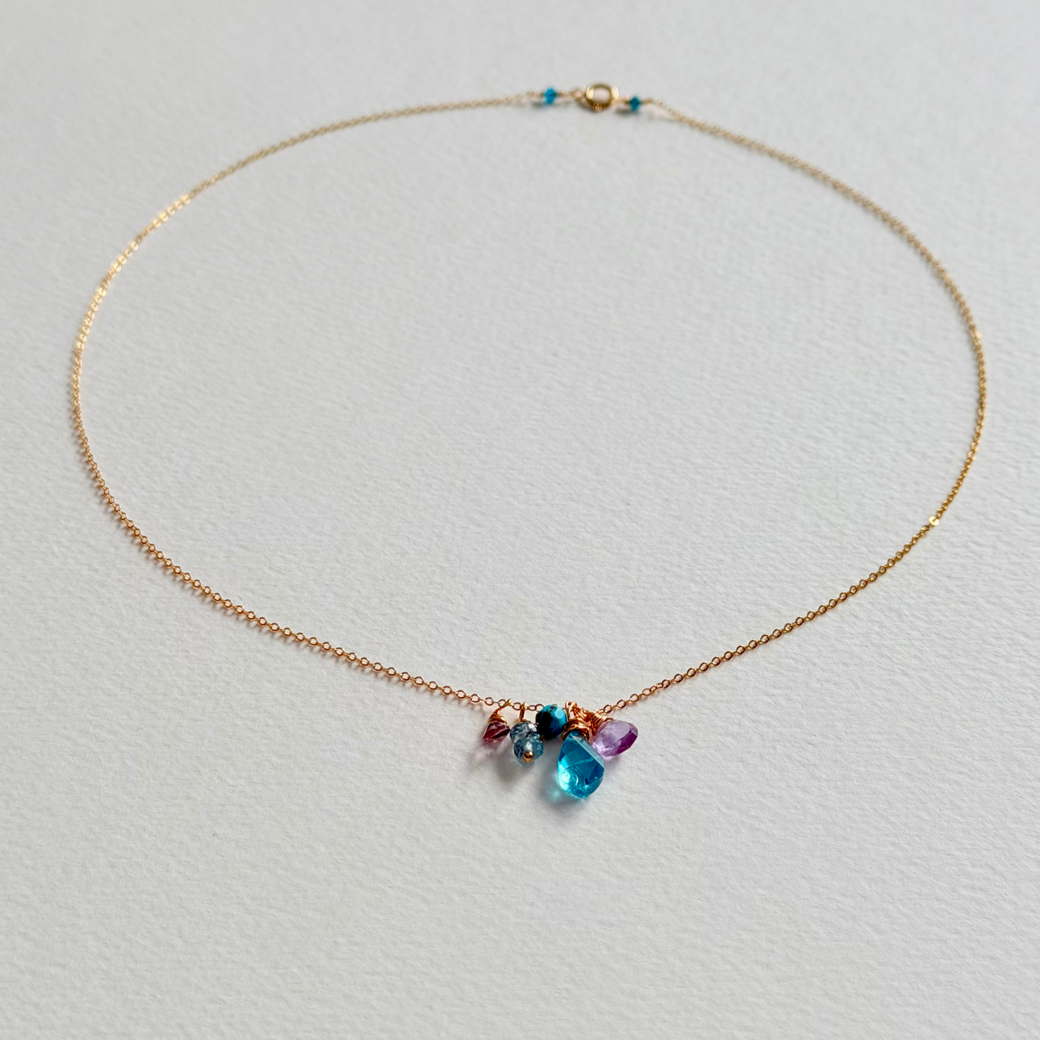 Necklace with multicolored gemstones on a light gray background
