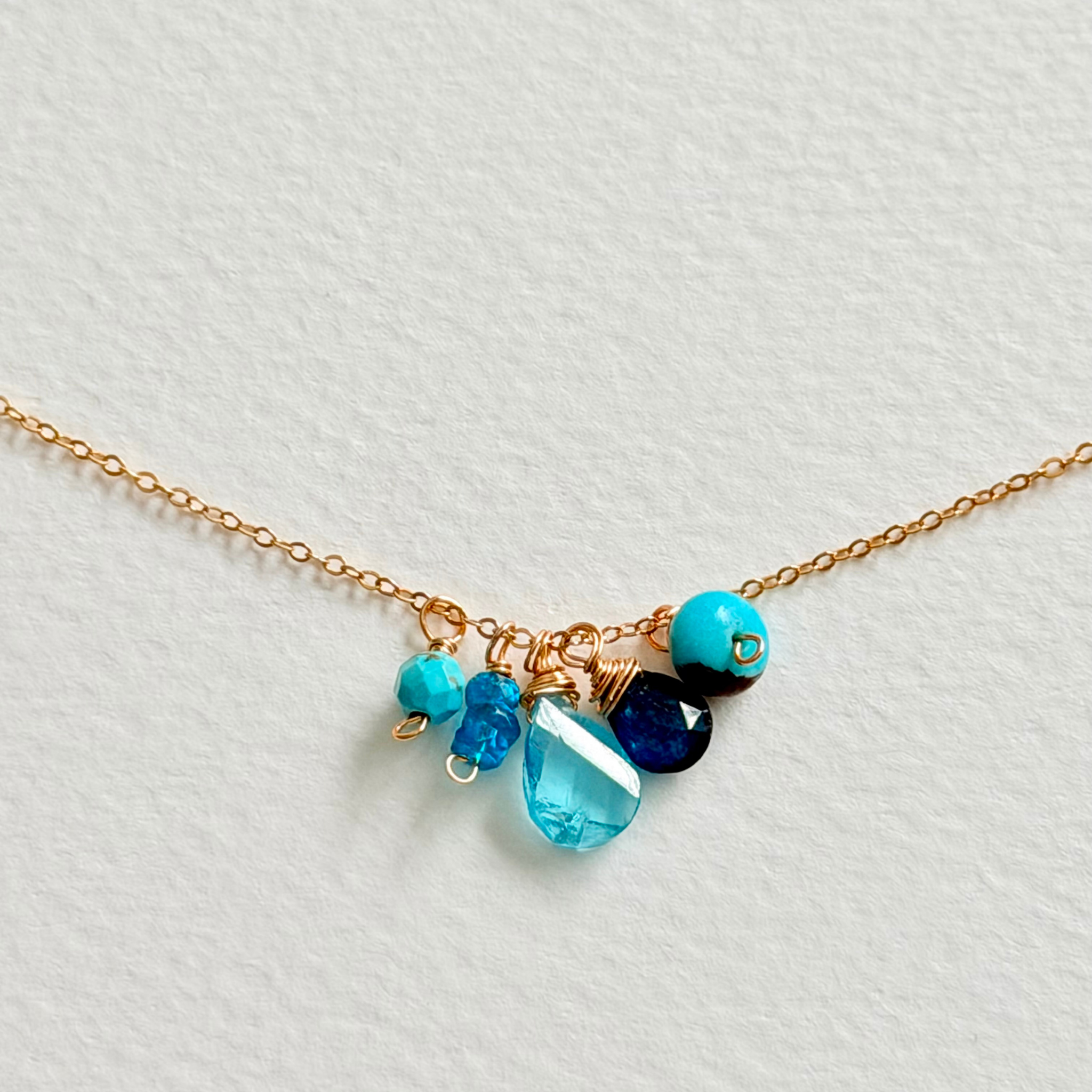 Necklace with blue and black beads on a light gray background