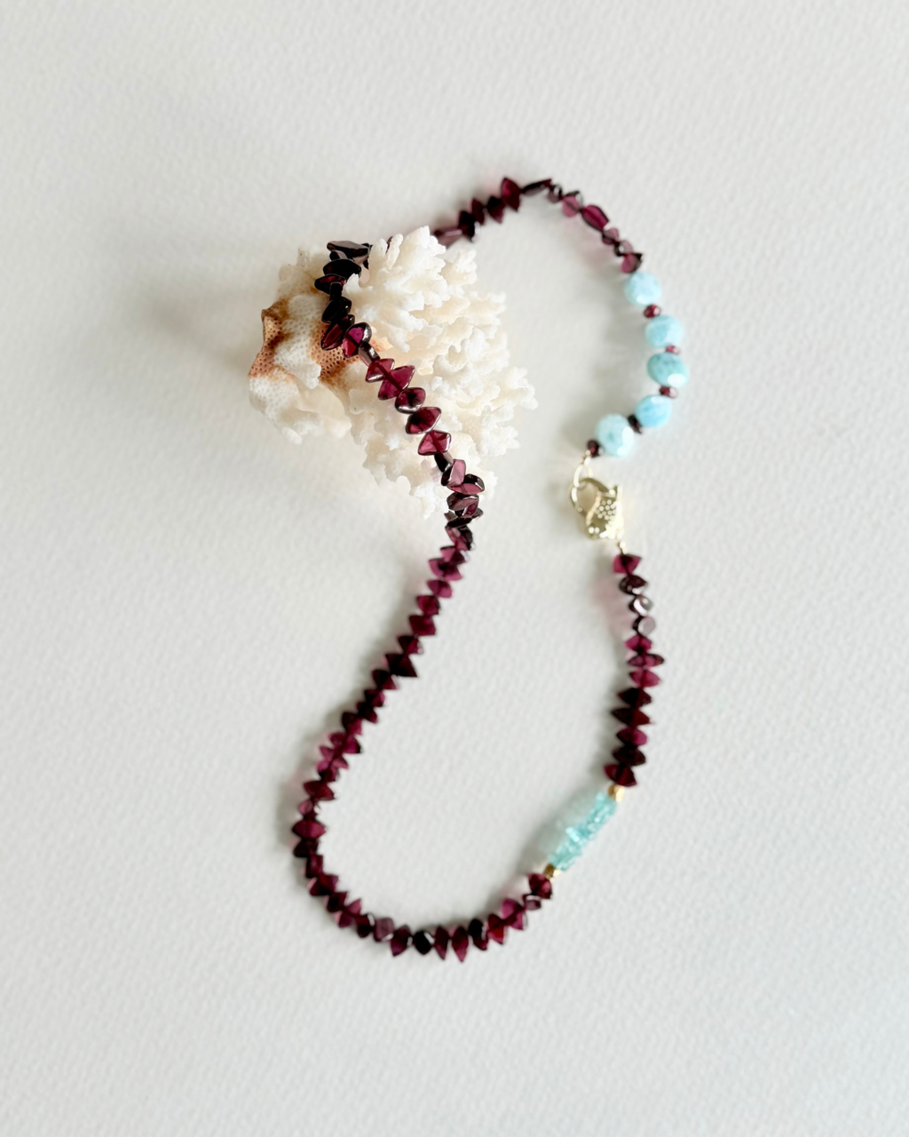 Deep Water garnet, larimar and aquamarine koi fish necklace on white background