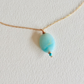 Necklace with a turquoise pendant on a white background