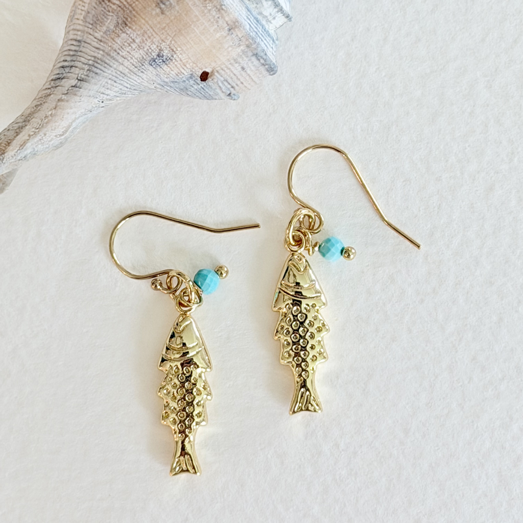 Gold fish-shaped earrings with turquoise beads on a white background