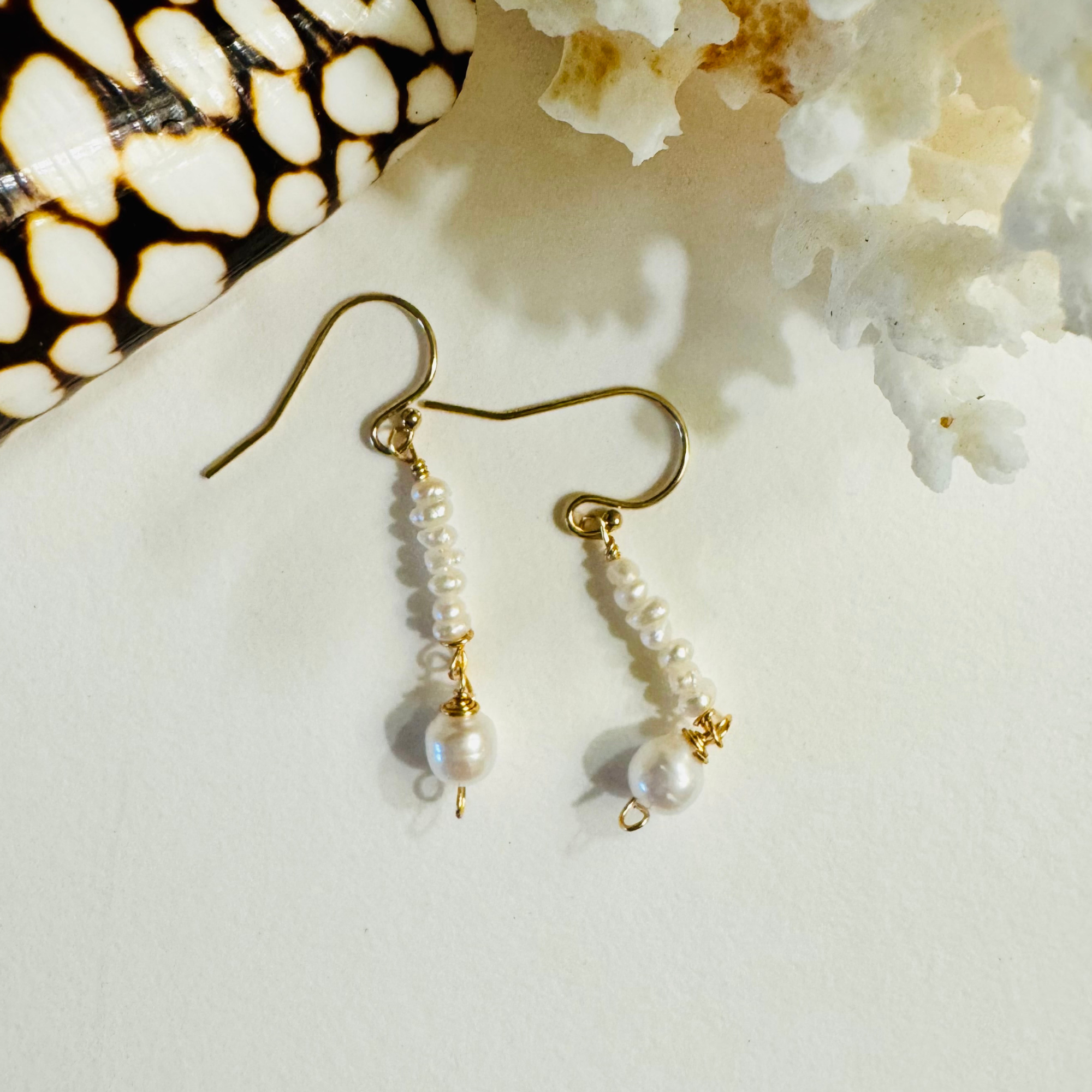Pearl earrings with gold accents on a light background