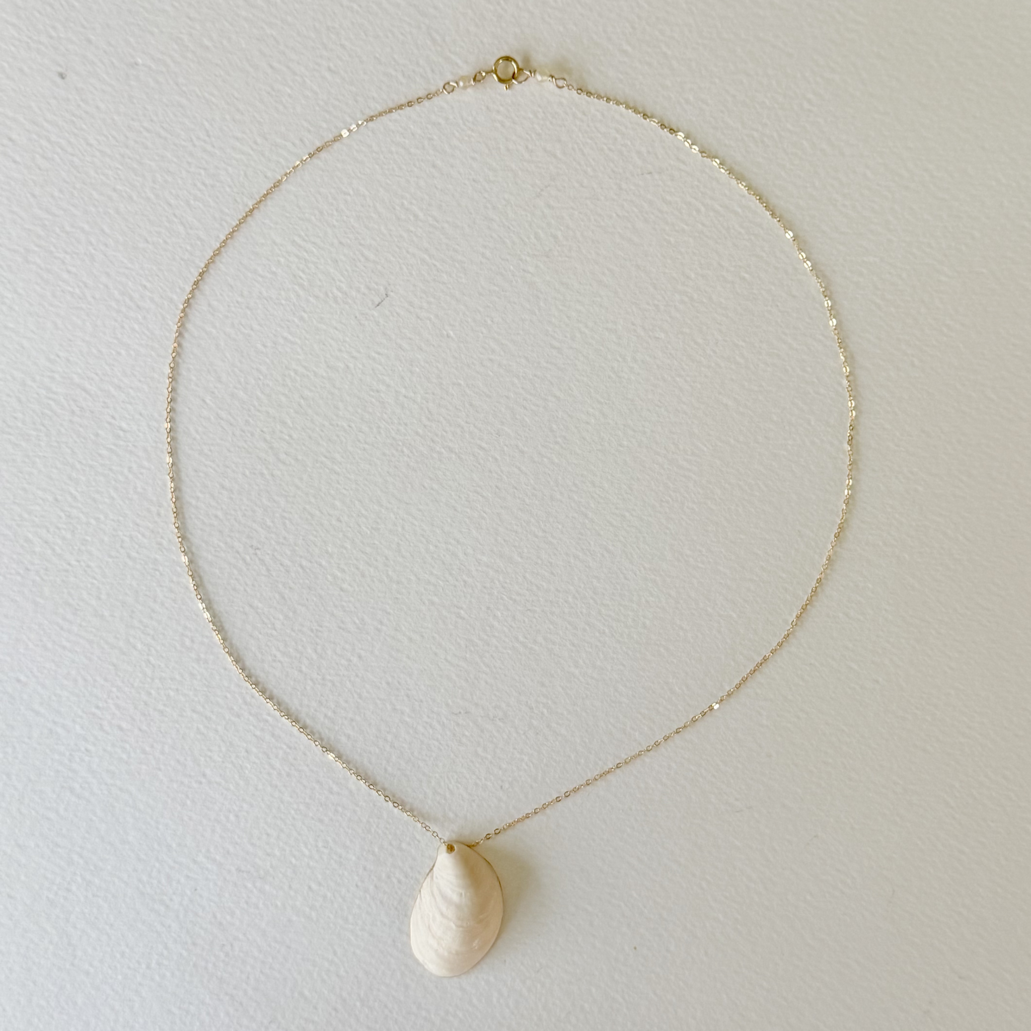 Necklace with a teardrop-shaped pendant on a light gray background