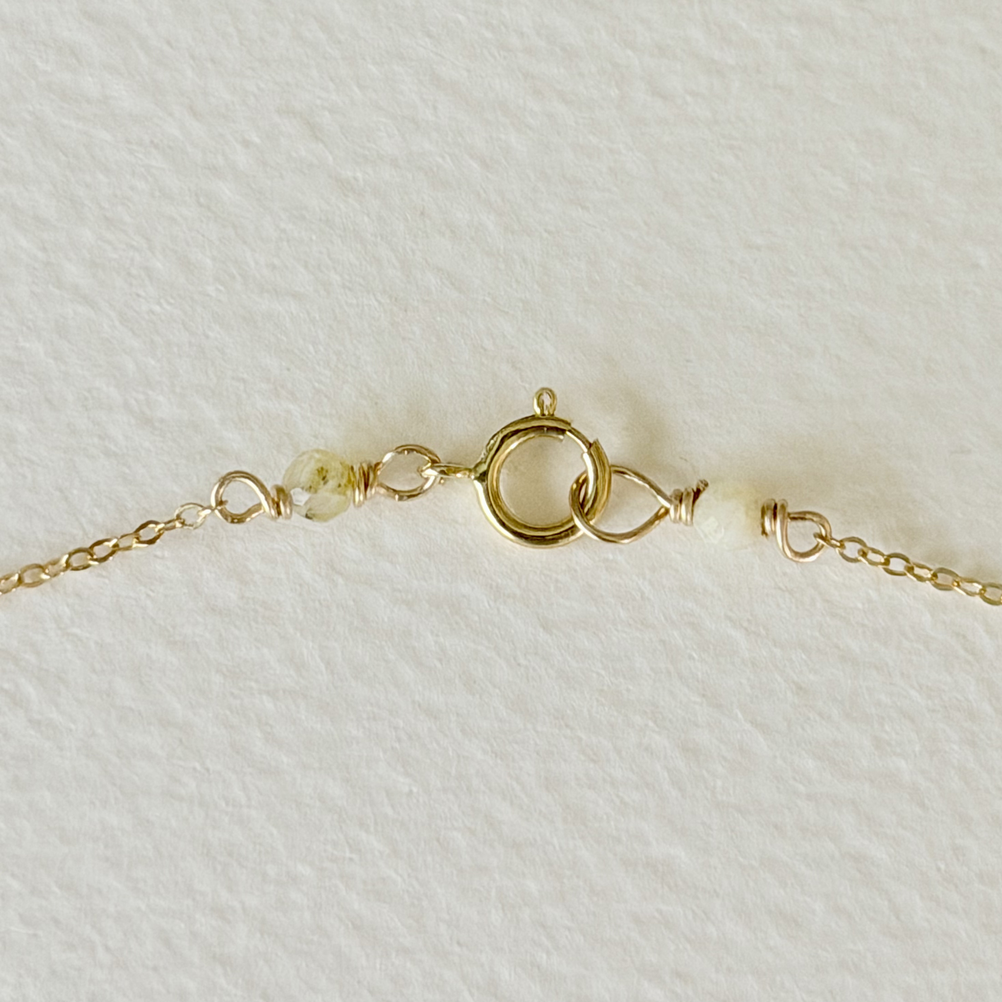 Gold bracelet with a clasp on a white fabric background