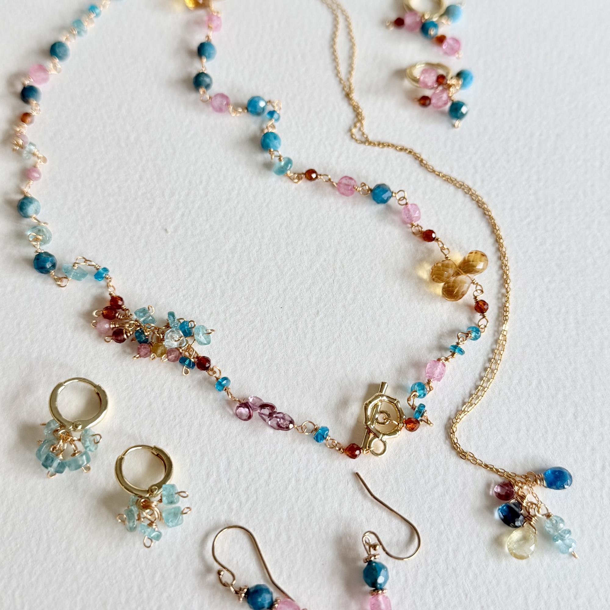 Multicolored beaded necklace and earrings on a white background