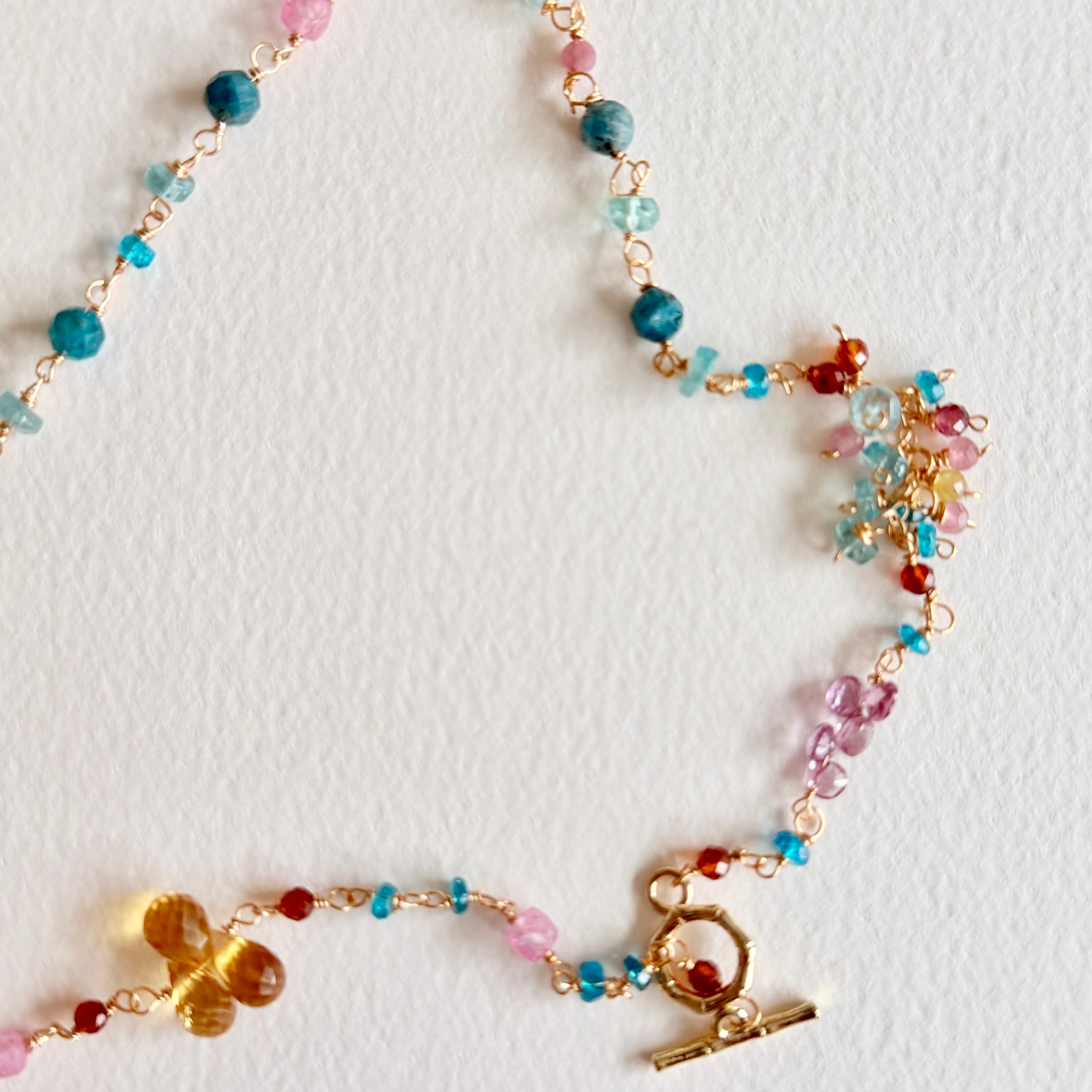 Colorful beaded necklace with gold clasp on a light background