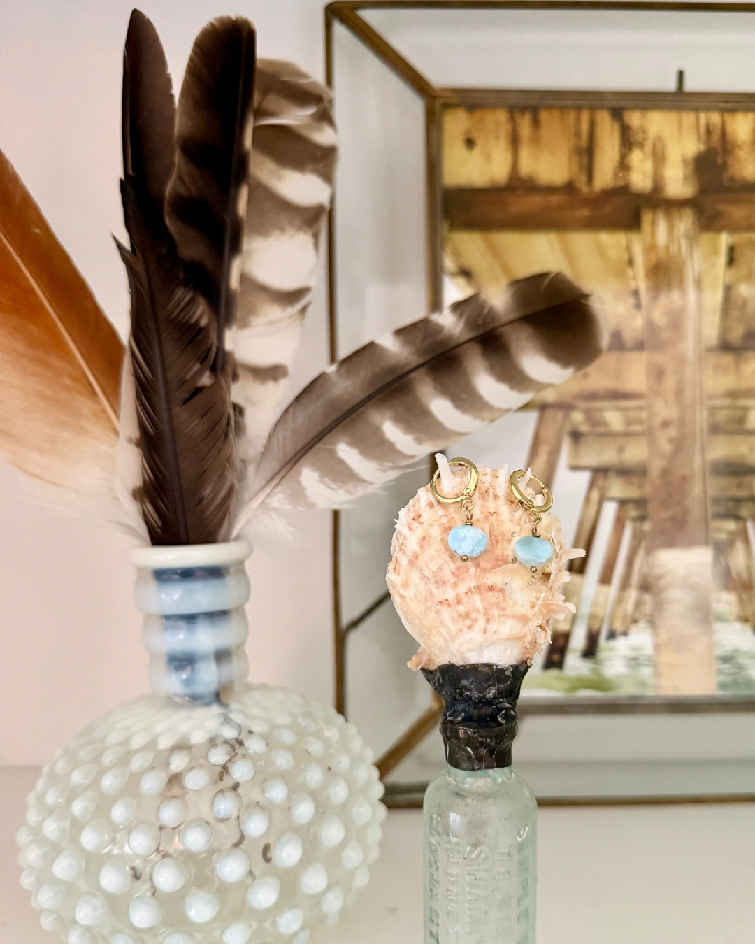 Larimar huggie earrings in coastal vignette with feathers