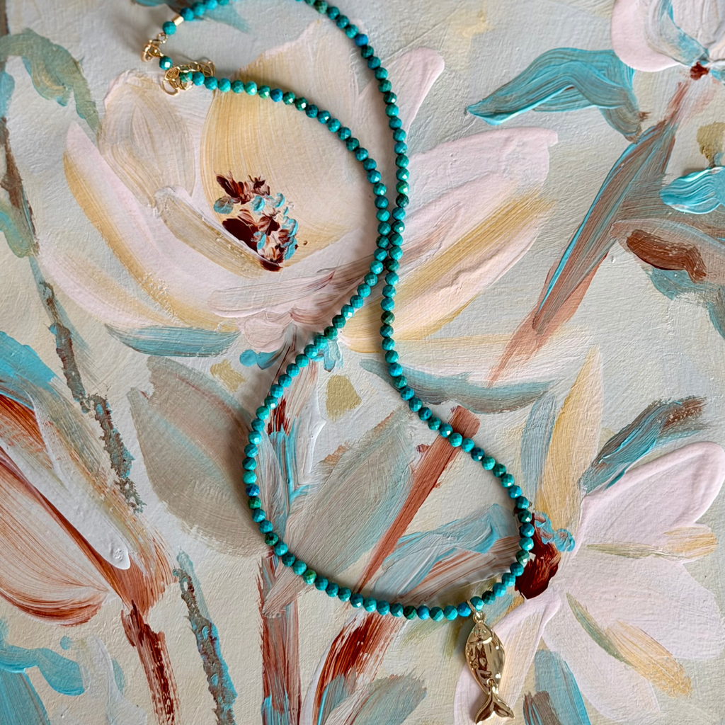 turquoise necklace with fish charm on a magnolia painting