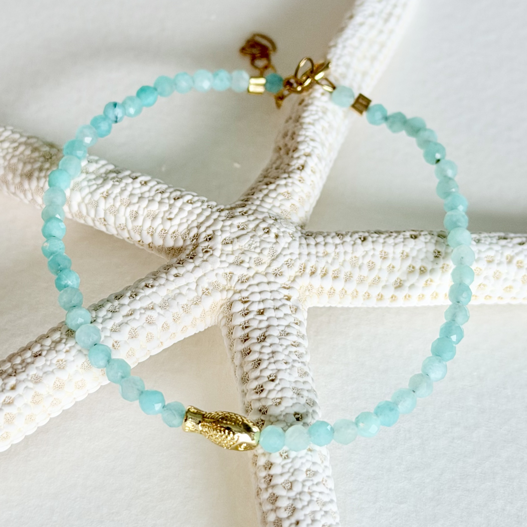 Turquoise beaded bracelet with gold accents on a starfish