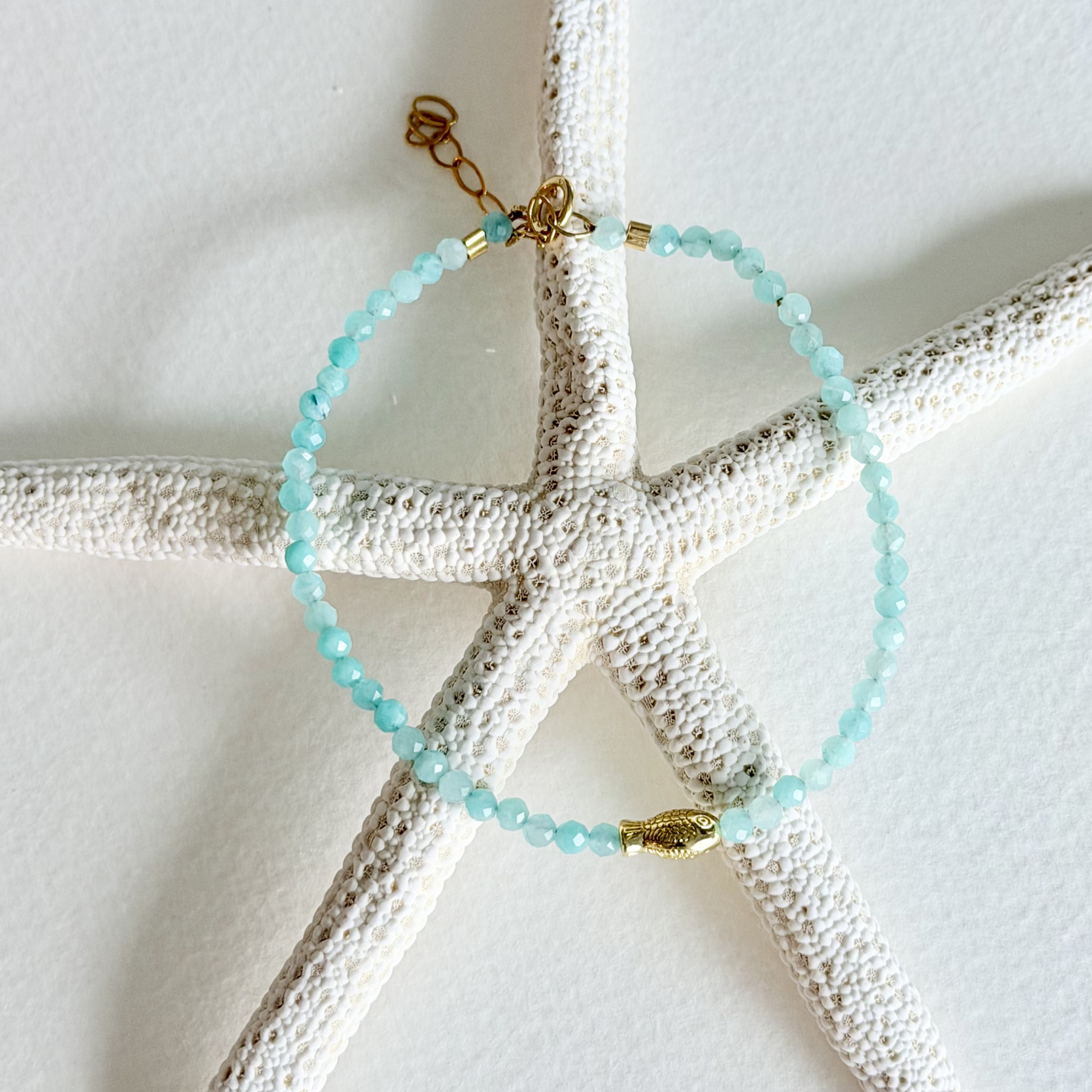 Turquoise beaded bracelet with gold accents on a starfish