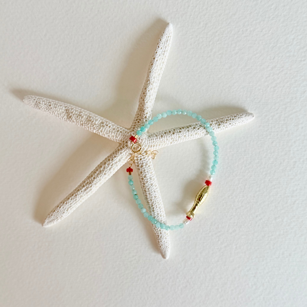 Bracelet with colorful beads on a starfish against a light background