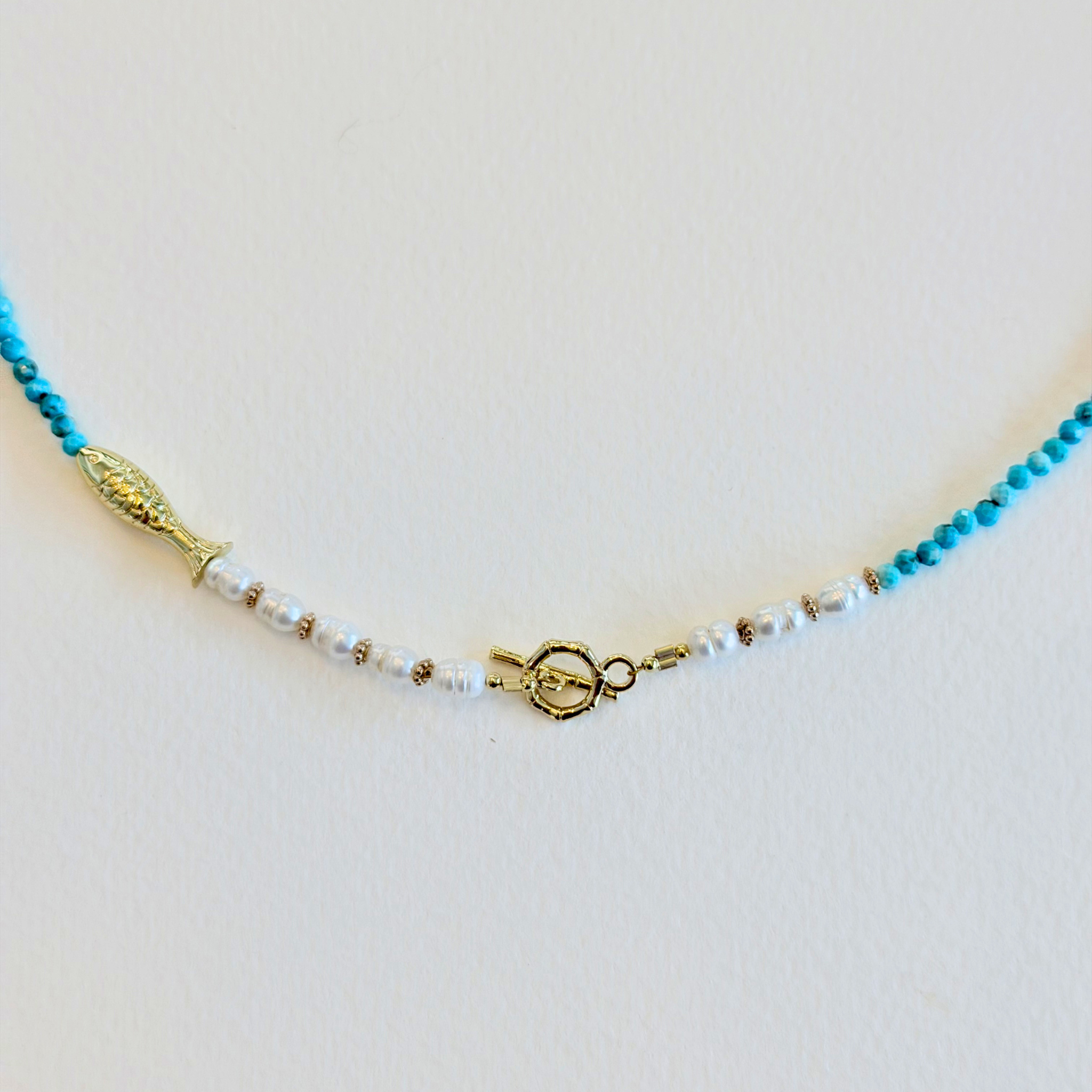 Necklace with blue and white beads on a light gray background