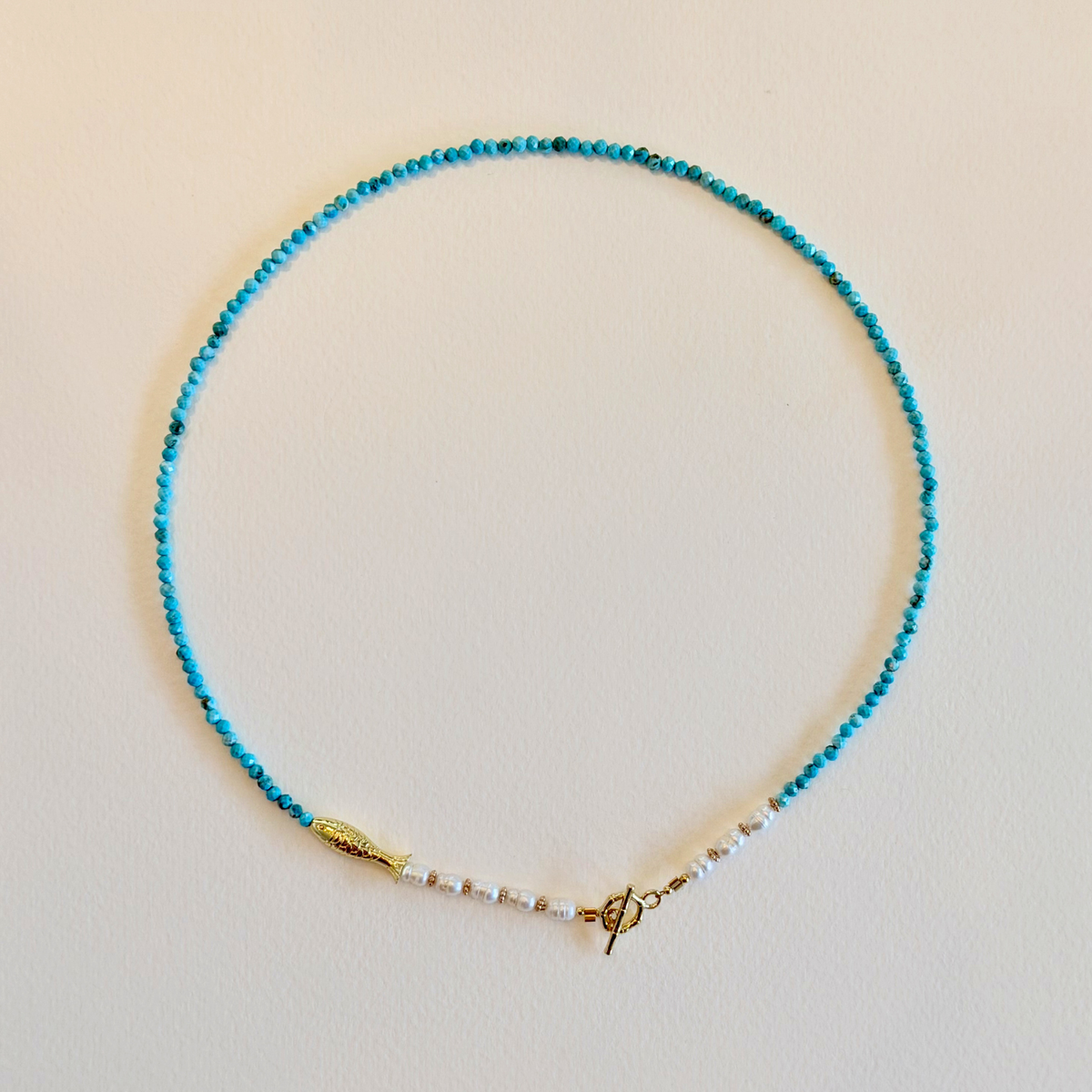 Necklace with blue beads on a beige background