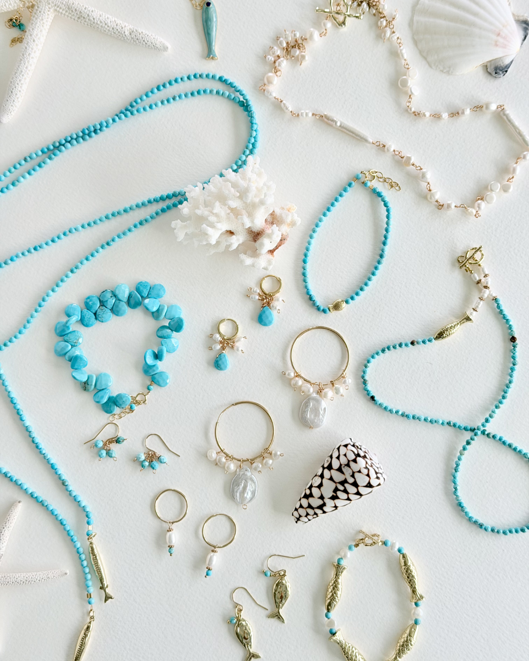 Jewelry set with turquoise and gold necklaces, bracelets, and earrings on a light background.