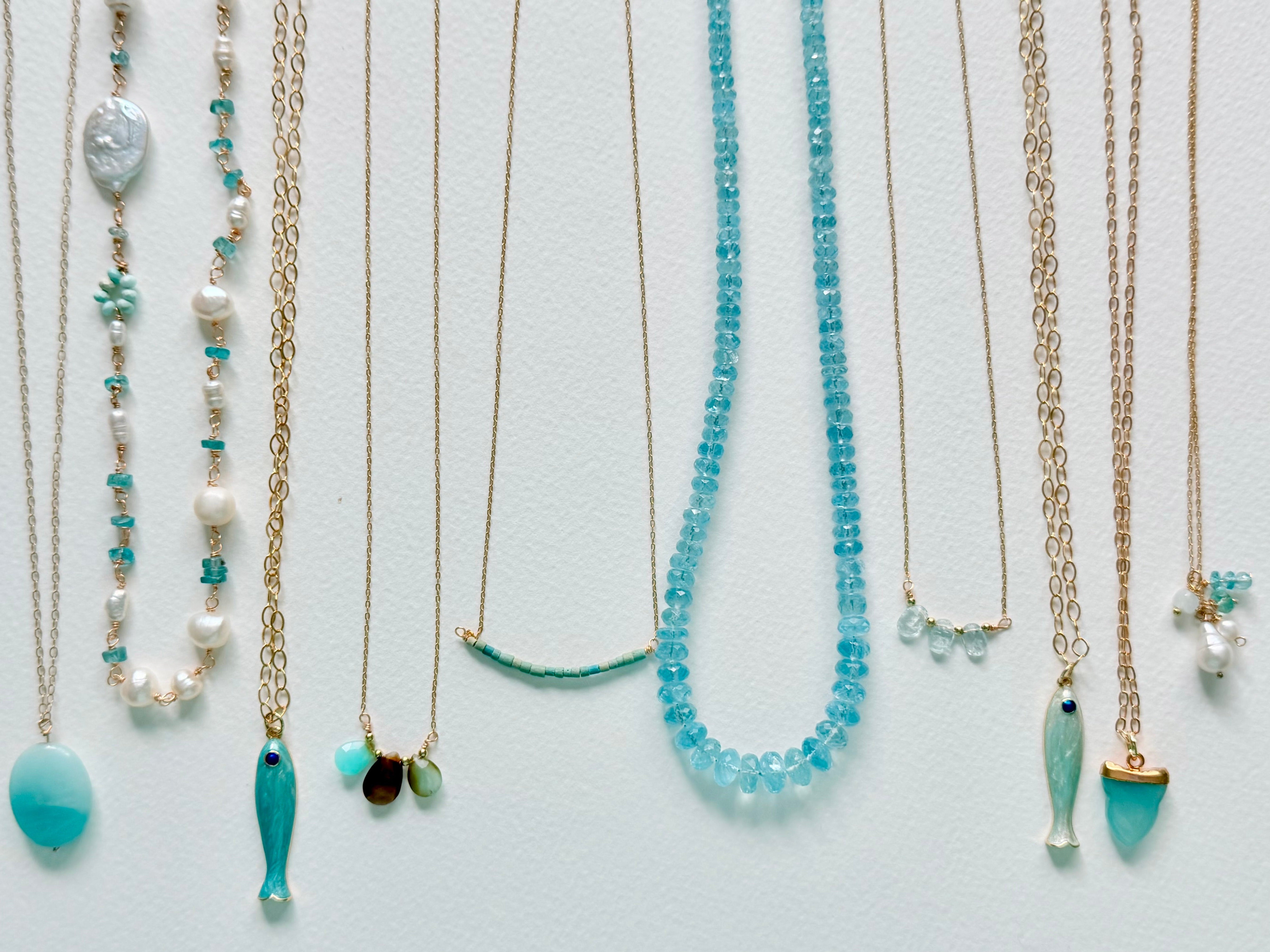 Set of necklaces with blue and gold elements on a light gray background