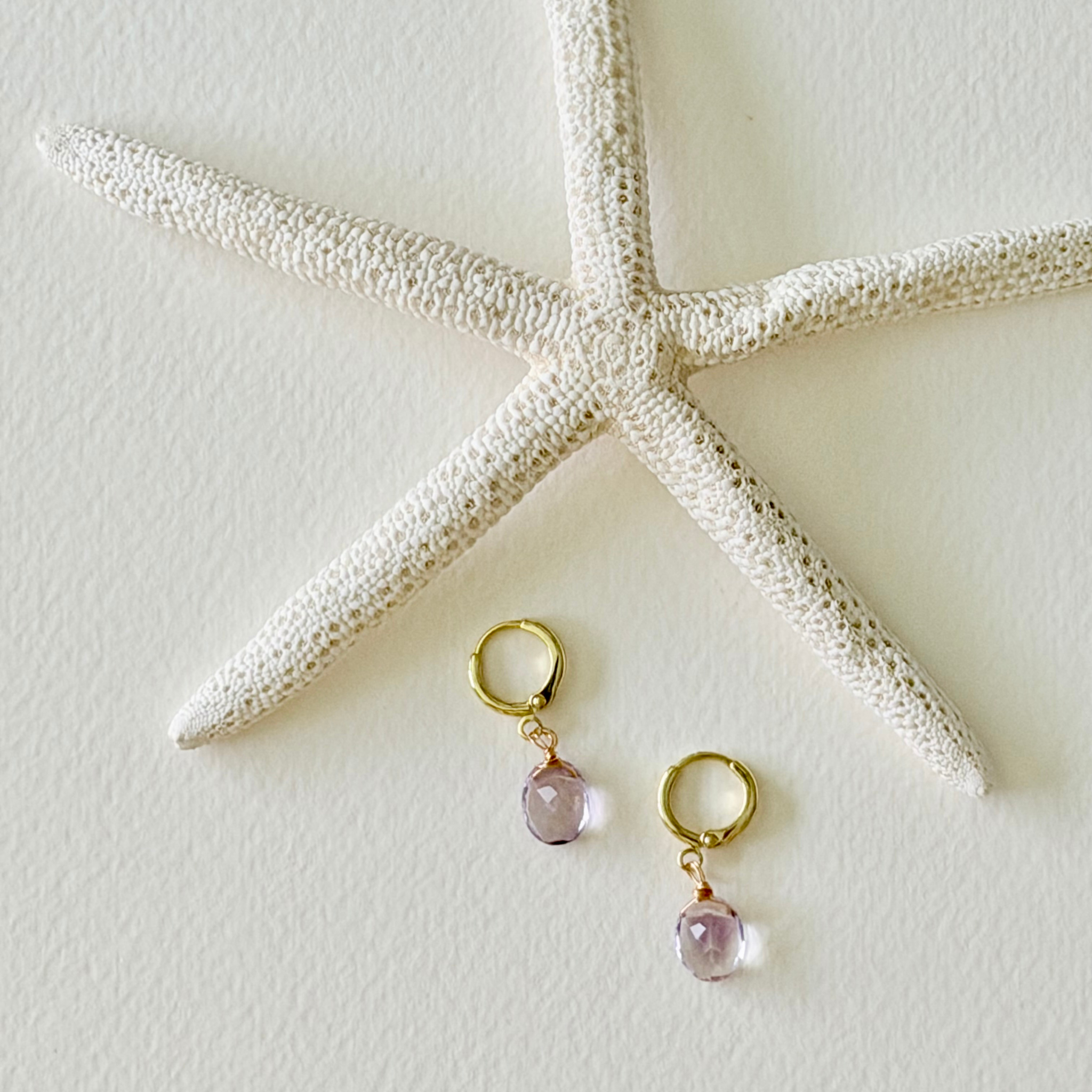 Pair of earrings with pink gemstones on a starfish