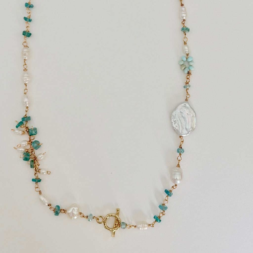 Necklace with green and white beads on a light gray background