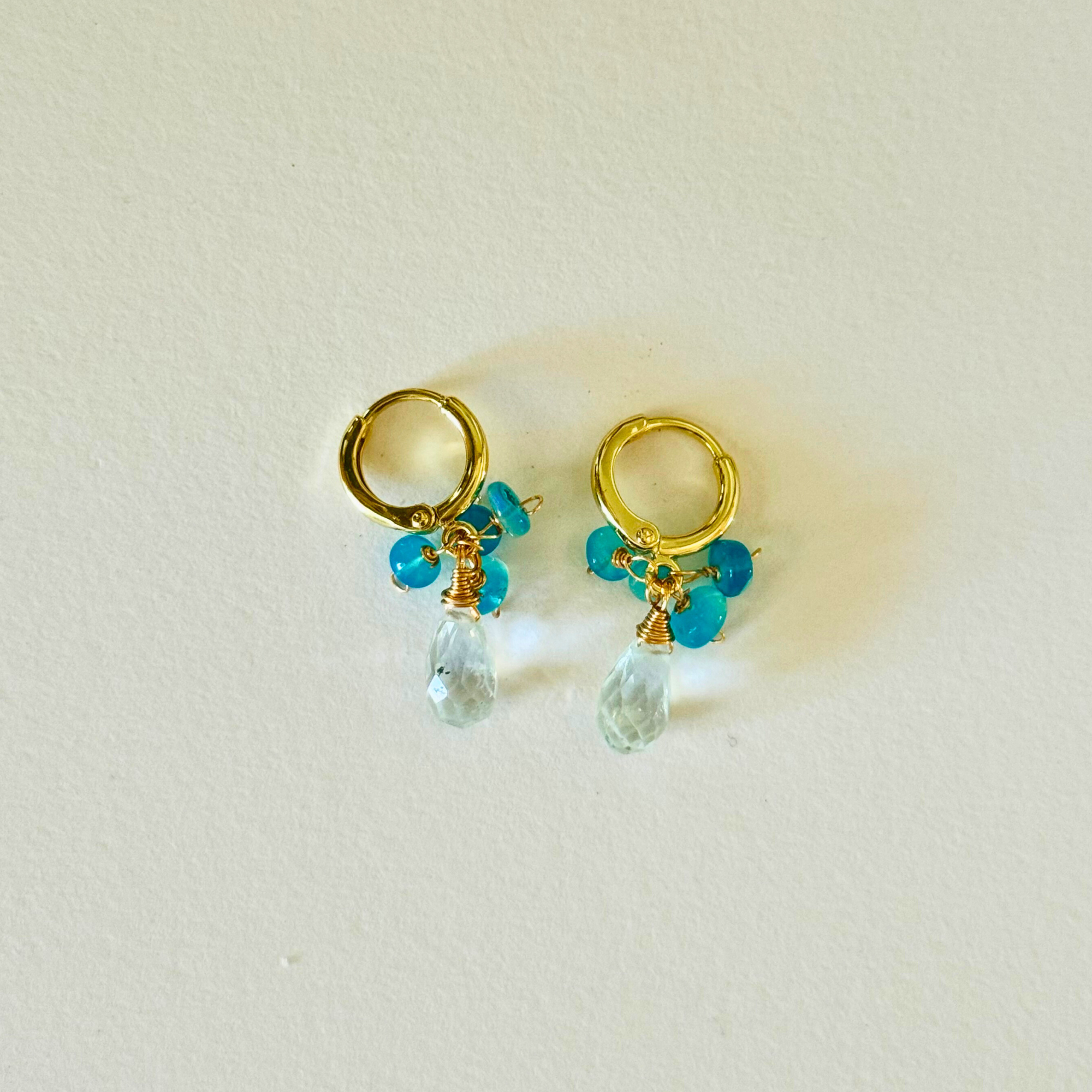 14k Gold filled huggie earrings with ethiopian blue opal and beryl clear bead drops on a light background