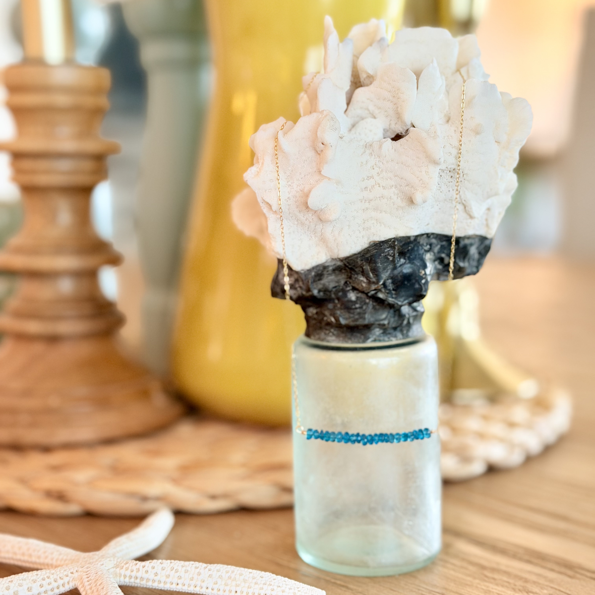 Decorative bottle with coral on a wooden surface