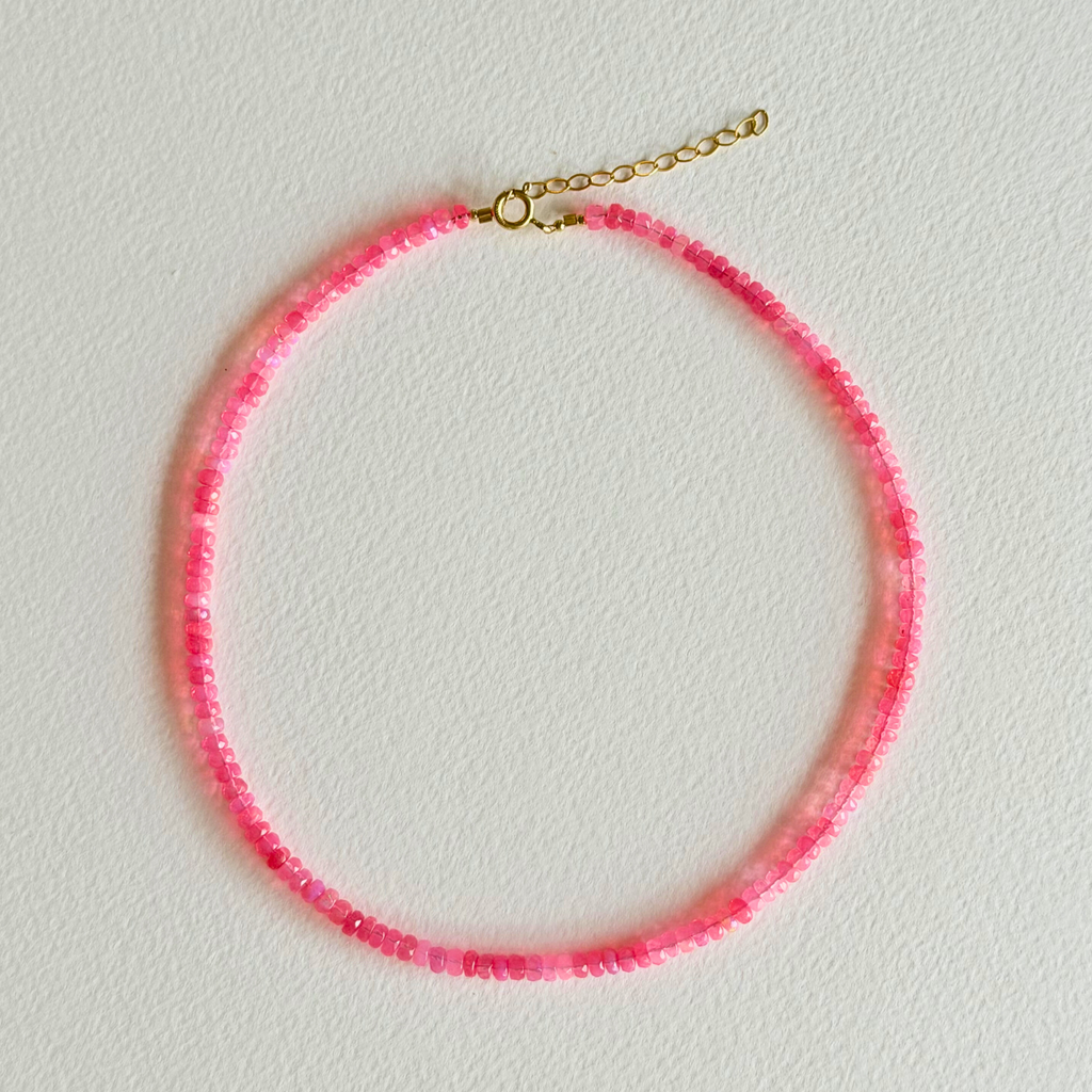 Necklace with pink beads on a light gray background