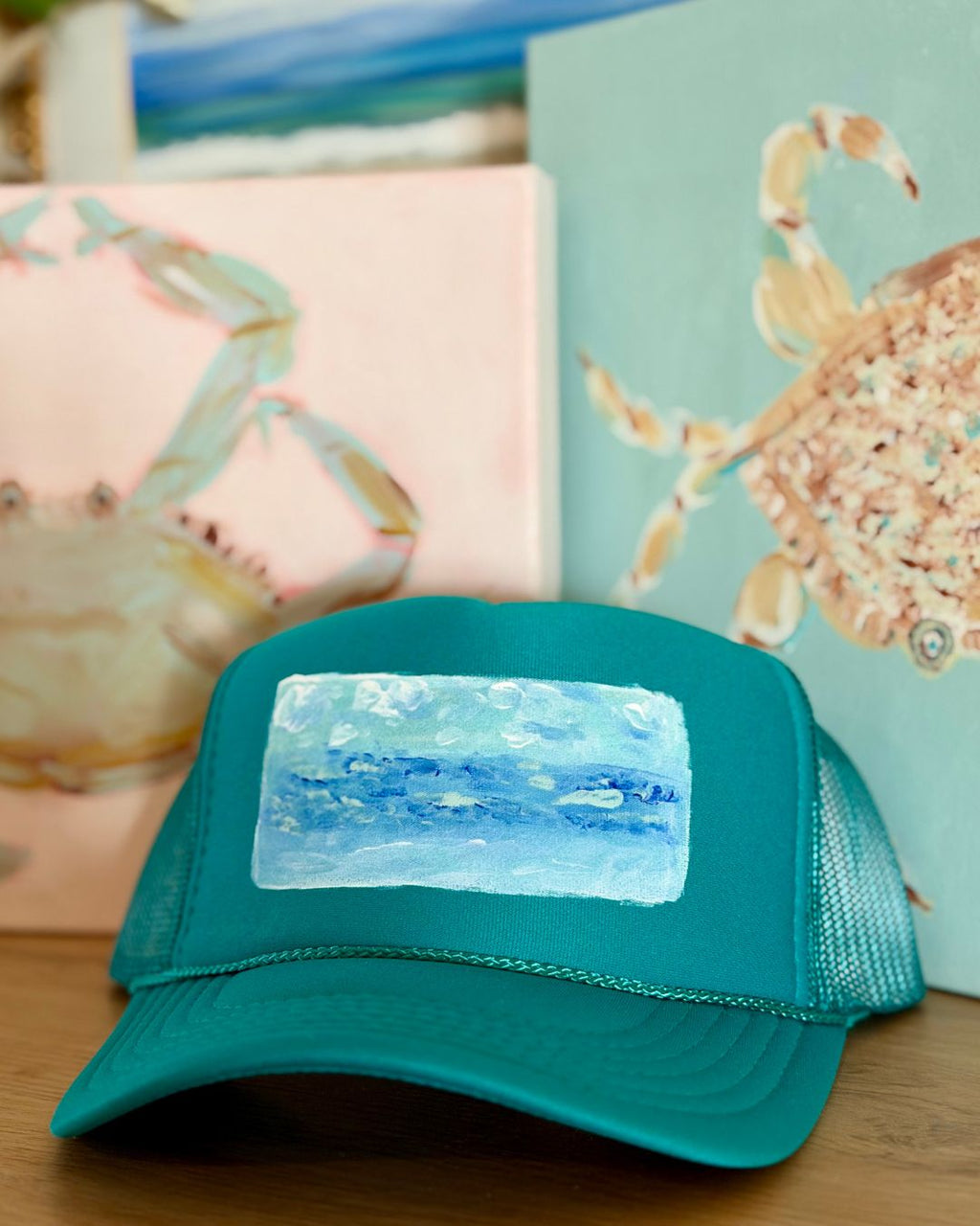 Turquoise trucker hat featuring an original hand-painted ocean landscape in soft blue, aqua and sandy tones by Marie & Oakley.