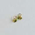 Pair of small green gemstone earrings on a light gray background